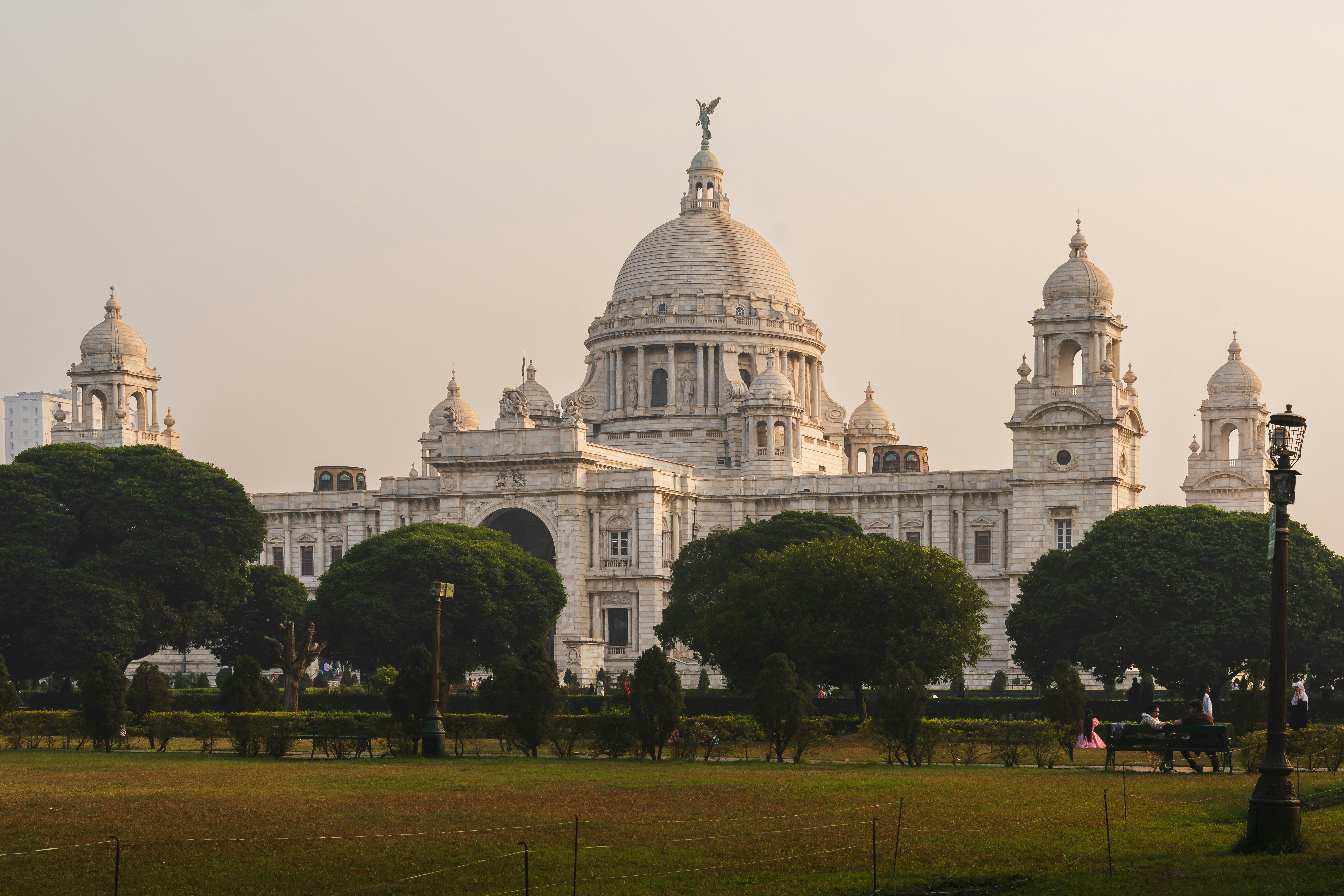 Grand white building with domes and trees