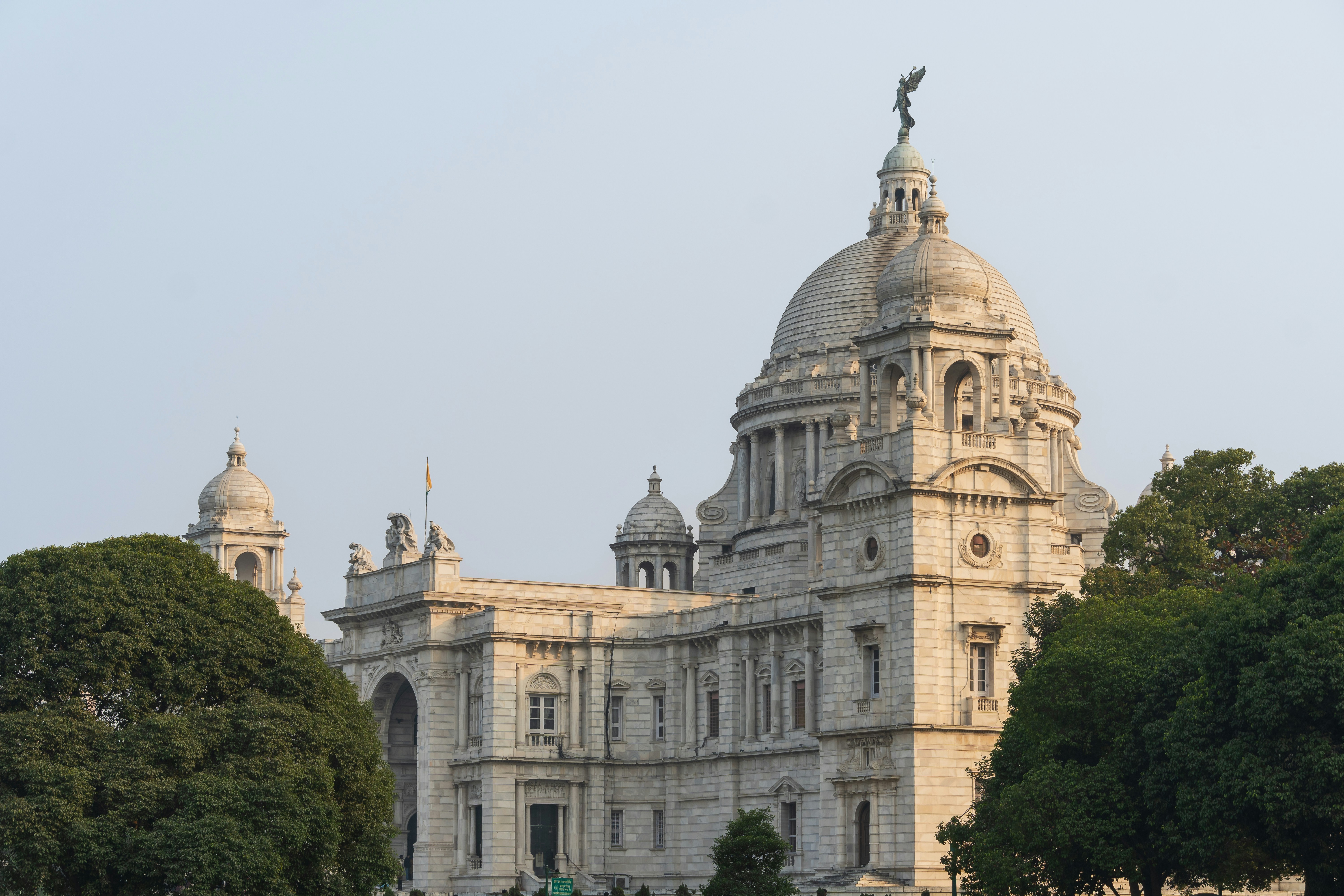 Grand white building with domes and trees