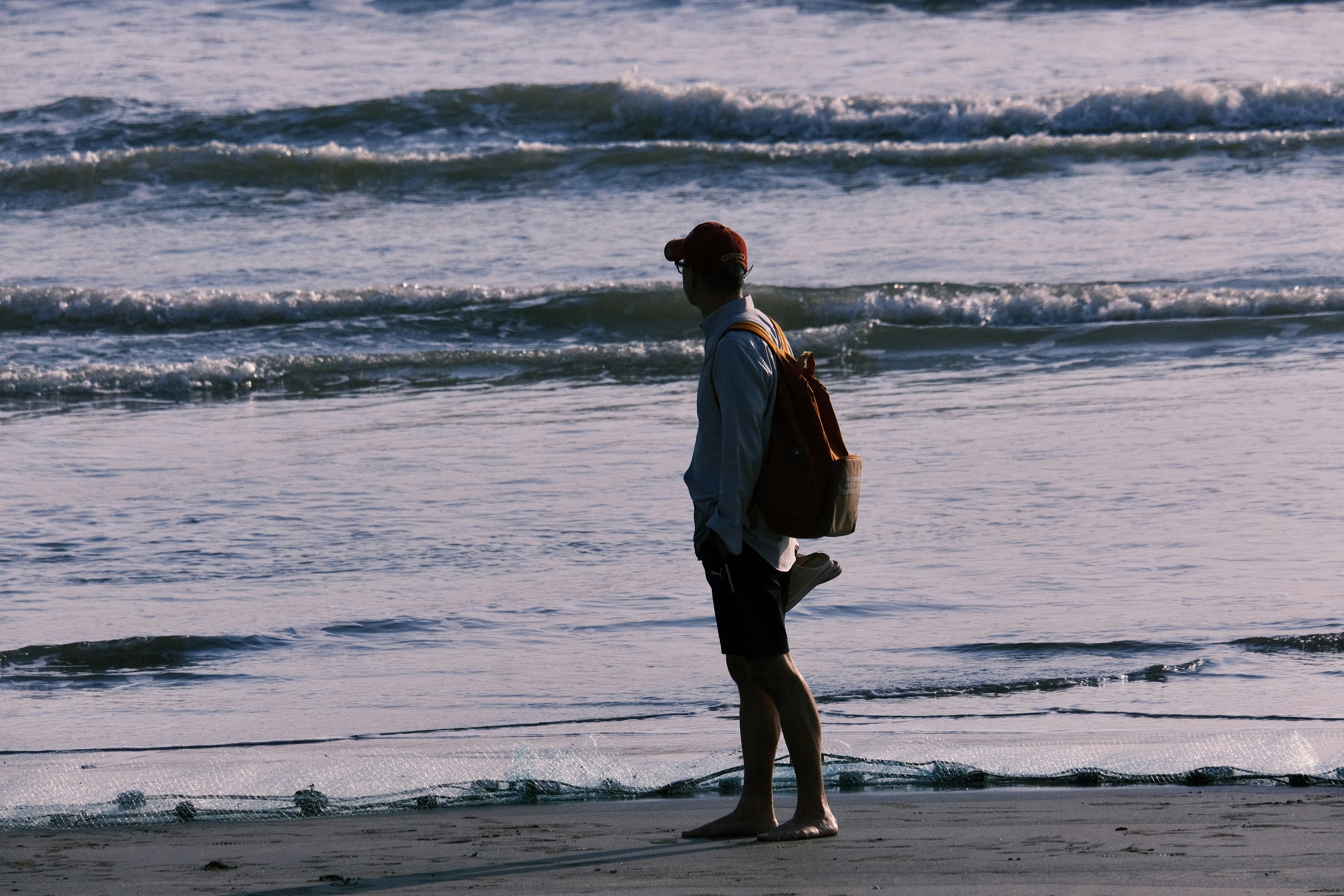 Man standing on a beach with ocean waves