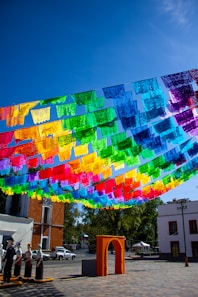Colorful papel picado flags strung across a sunny plaza.