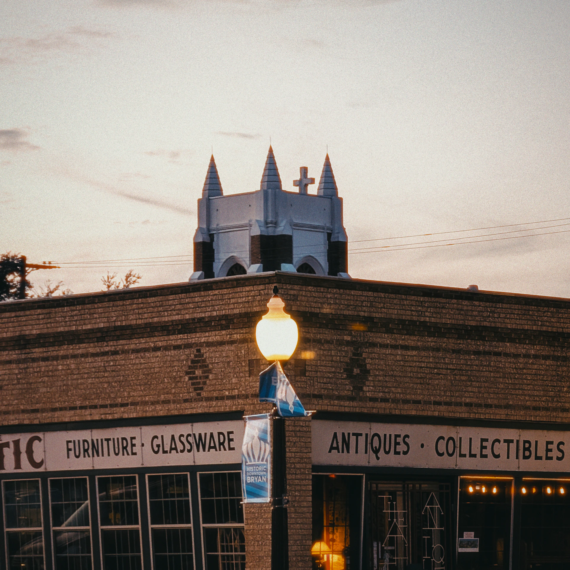 Brick building with antique shop signs at dusk