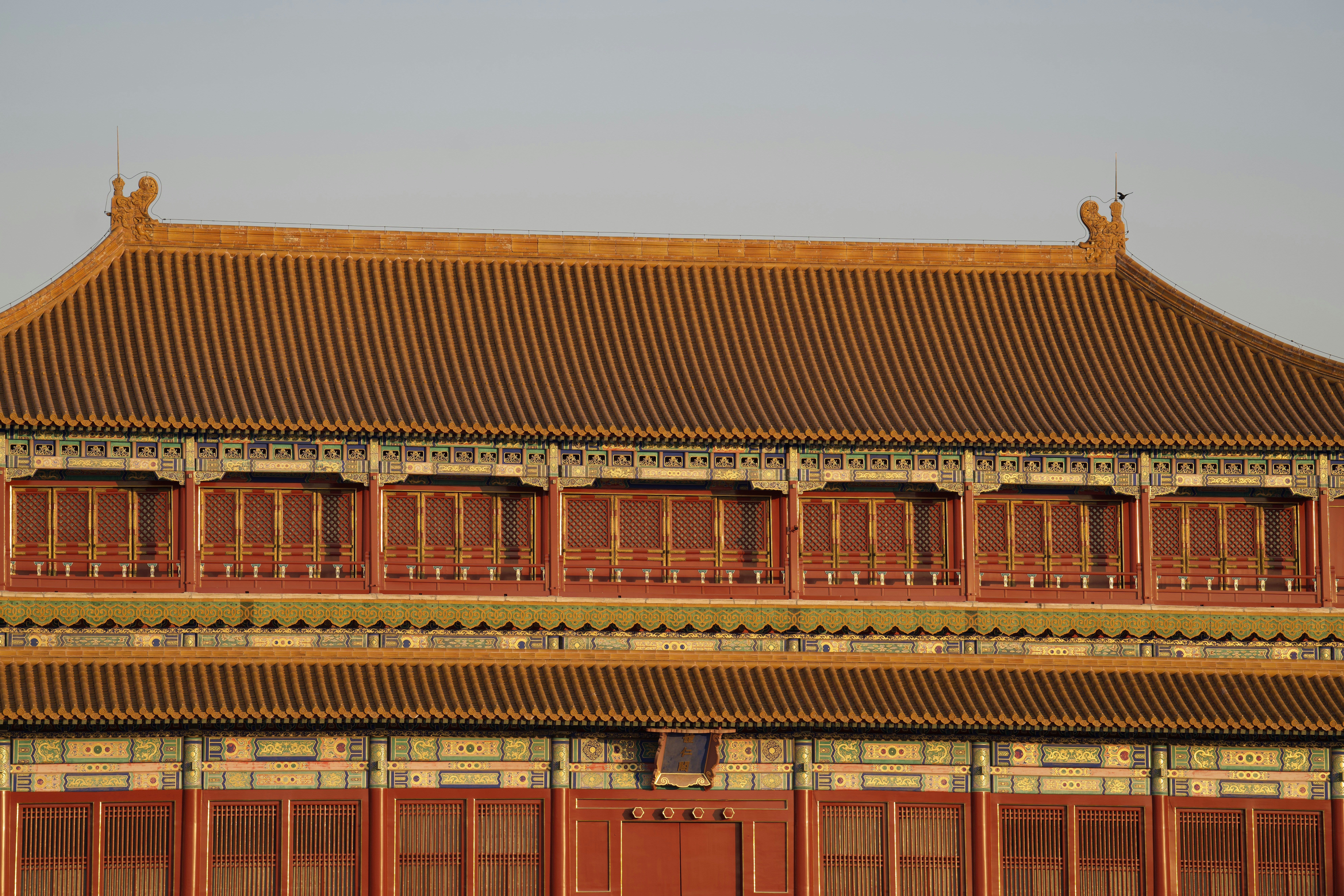 Traditional chinese palace roof with ornate windows.
