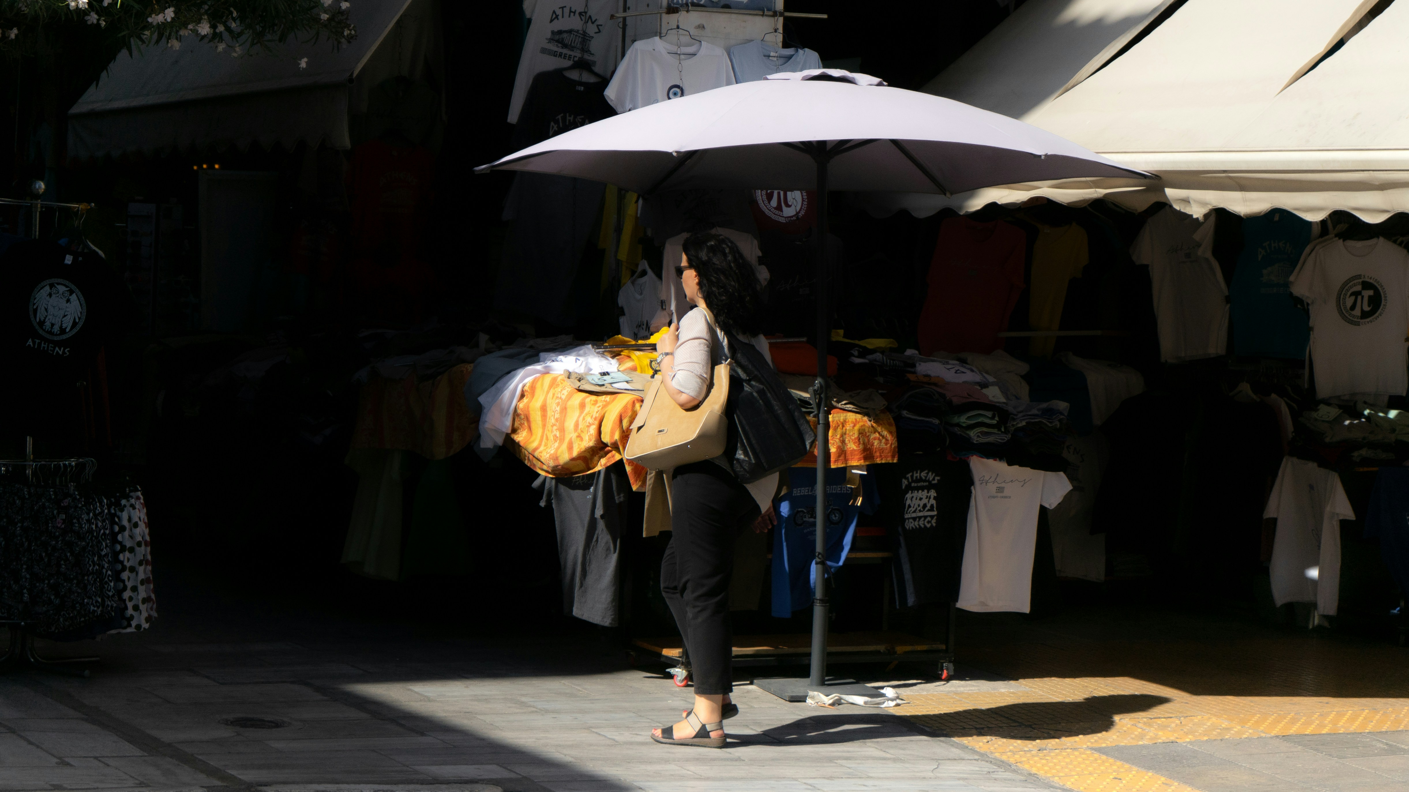 Woman carrying laundry under an umbrella