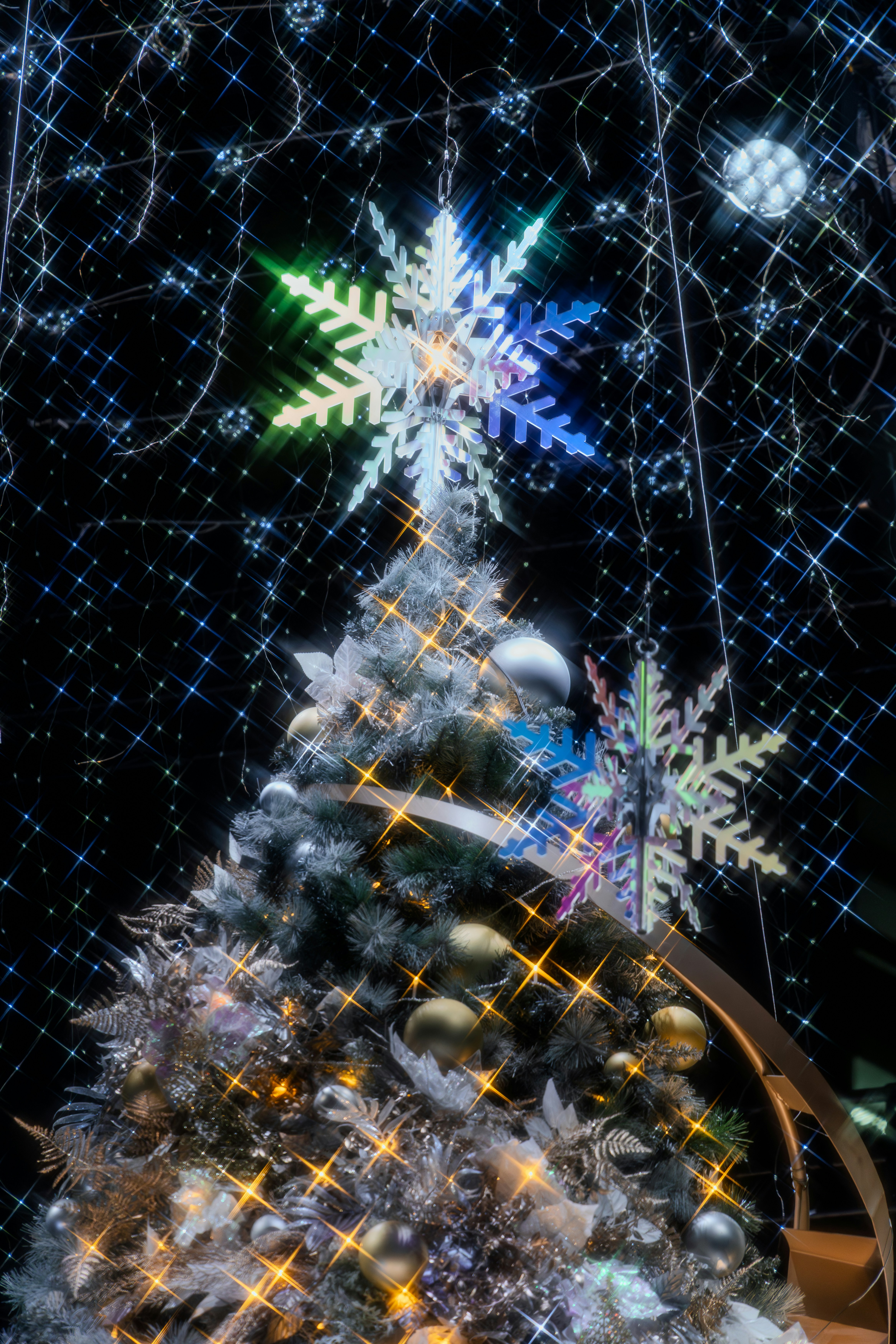 Decorated christmas tree with snowflake ornaments and star lights.