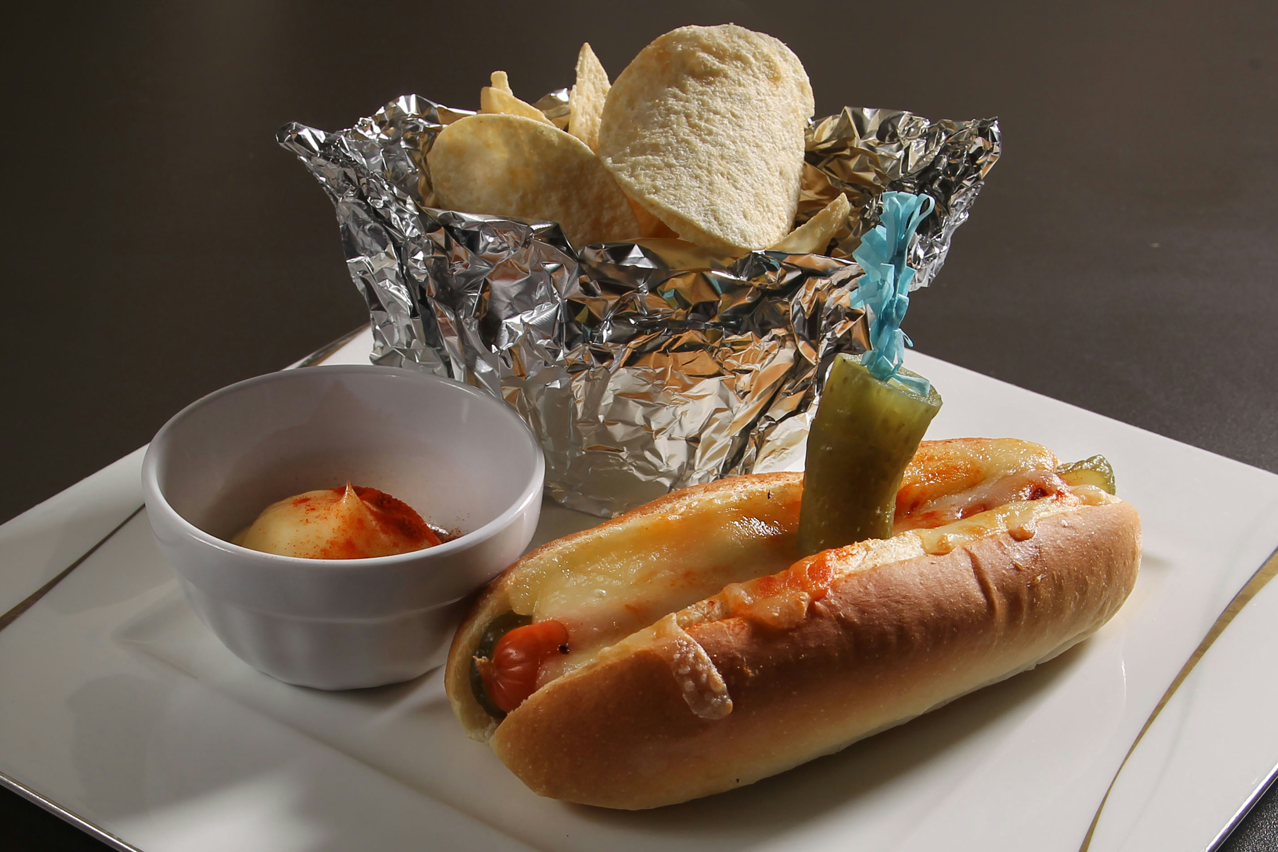 Hot dog with chips and dipping sauce