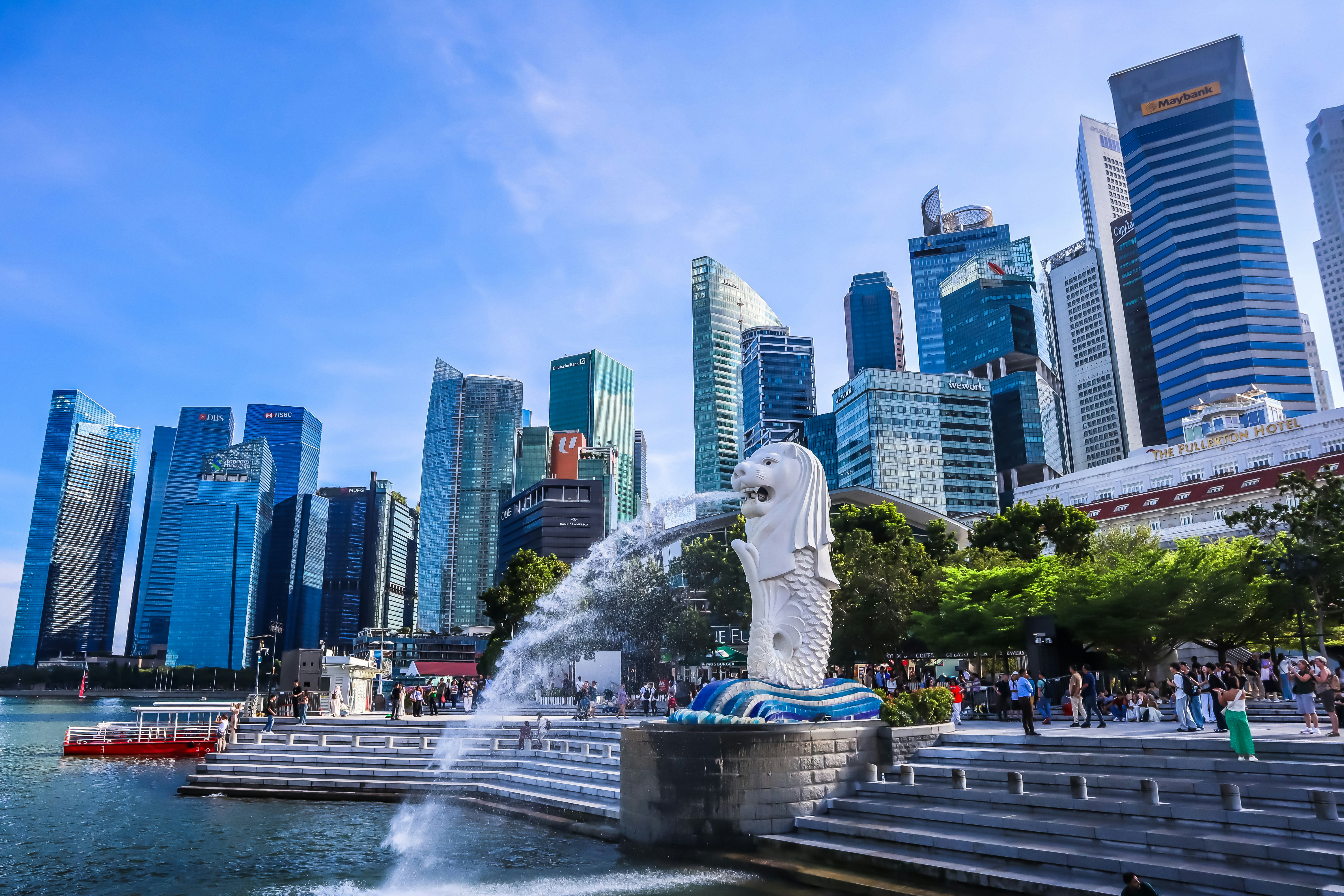 Merlion statue with singapore skyline and blue sky