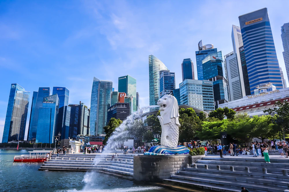 Pomnik Merlion na tle panoramy Singapuru i błękitnego nieba
