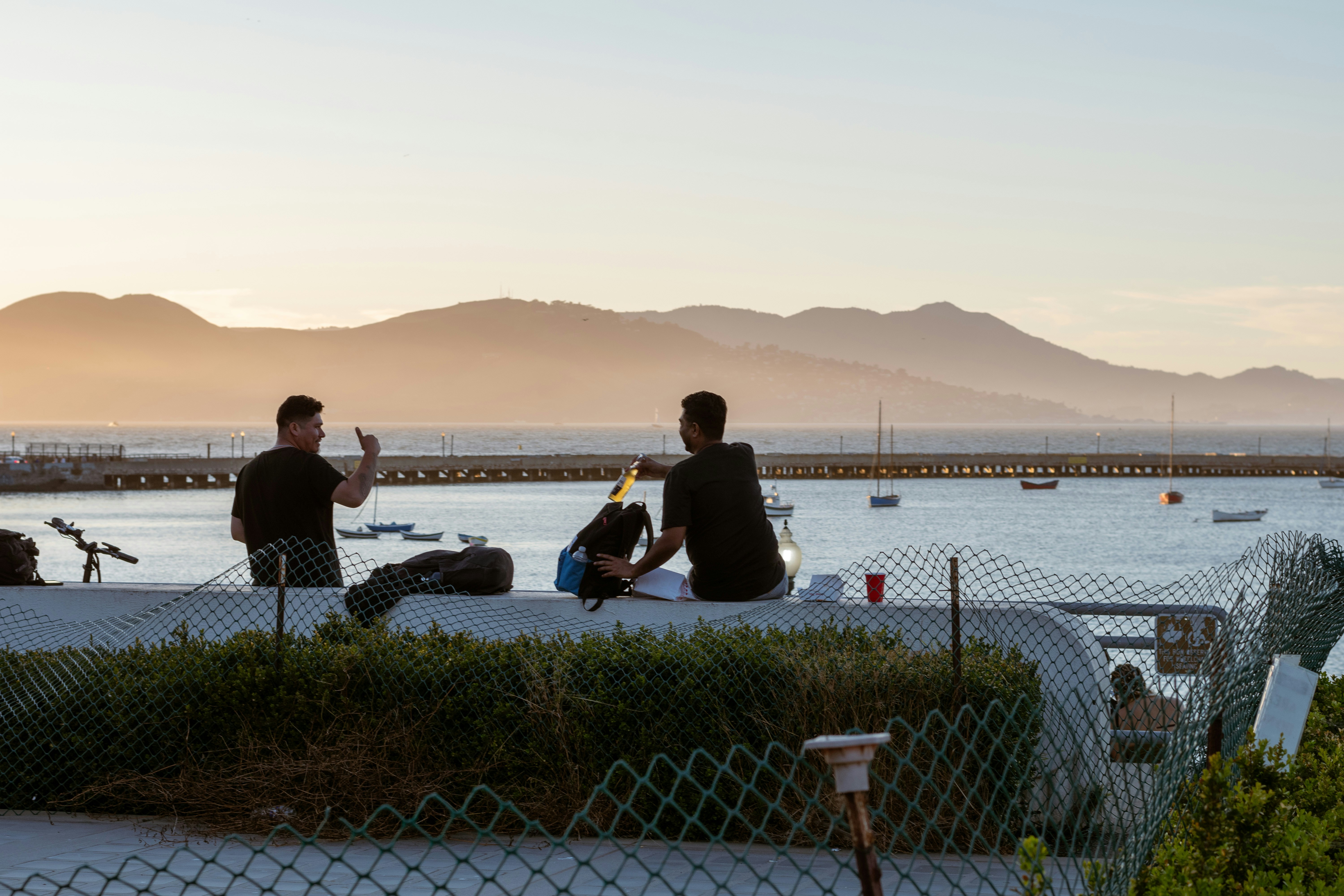 People gathered by the water at sunset