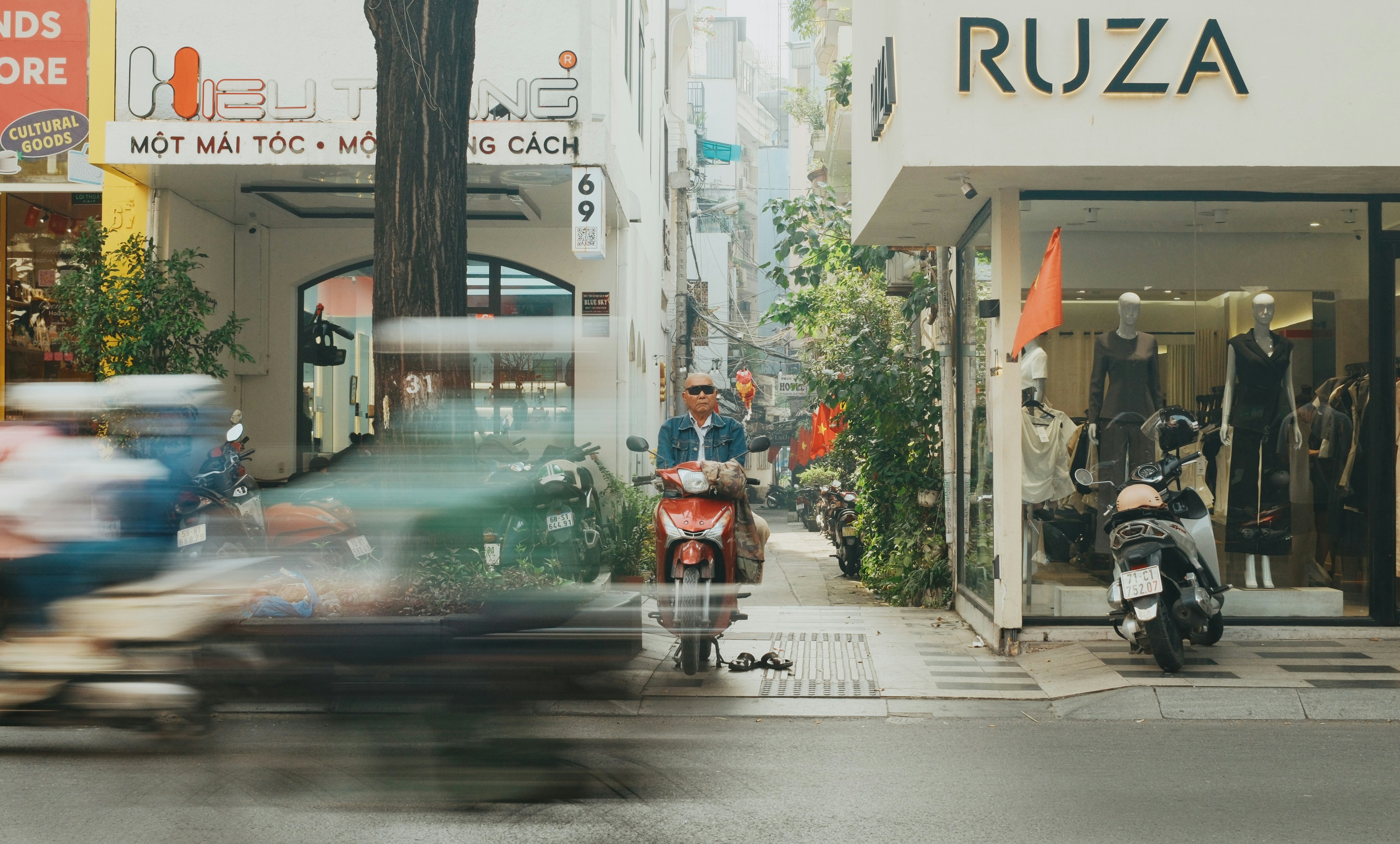 Motorcyclists and pedestrians on a busy city street.