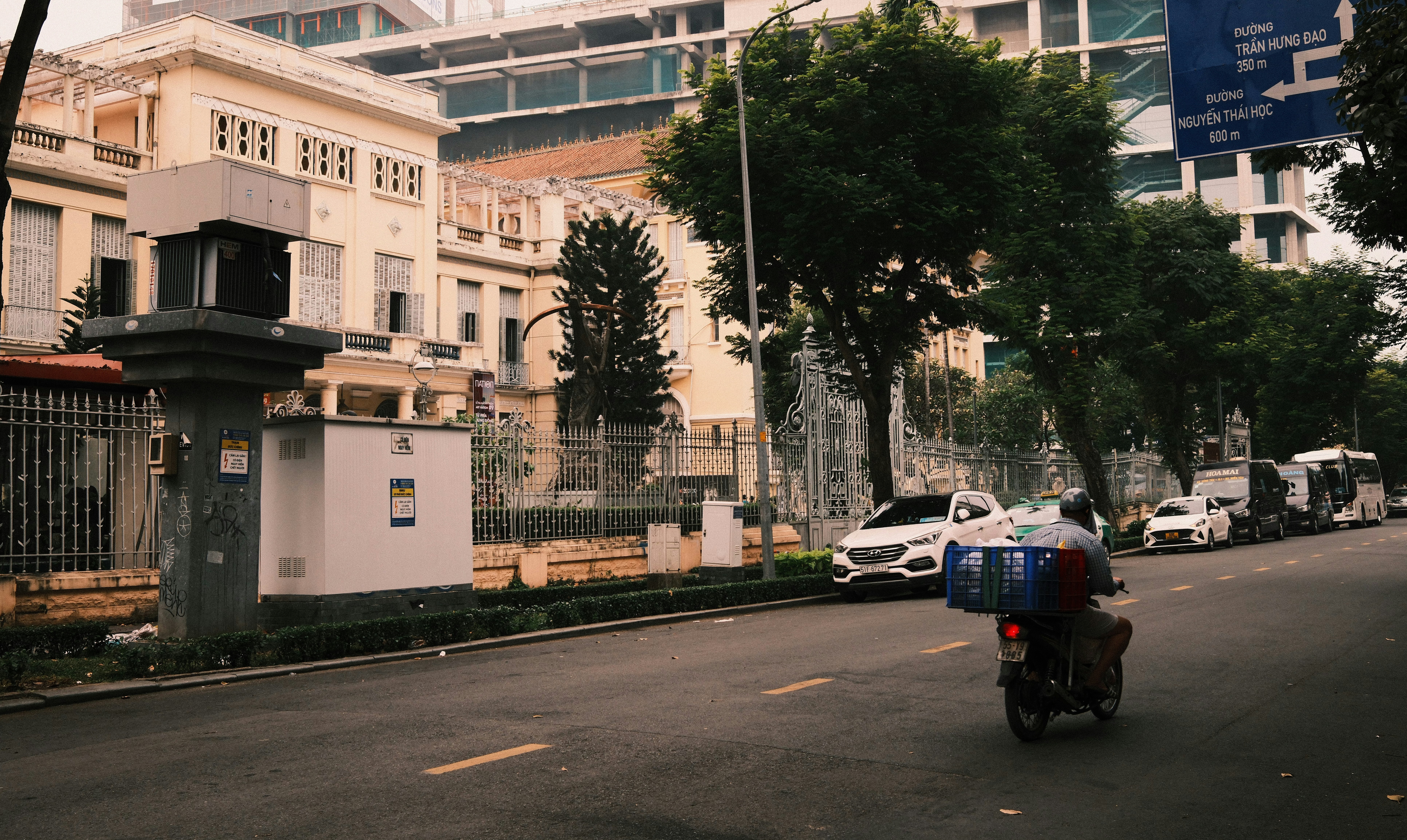 Motorcyclist on a street with buildings and trees.