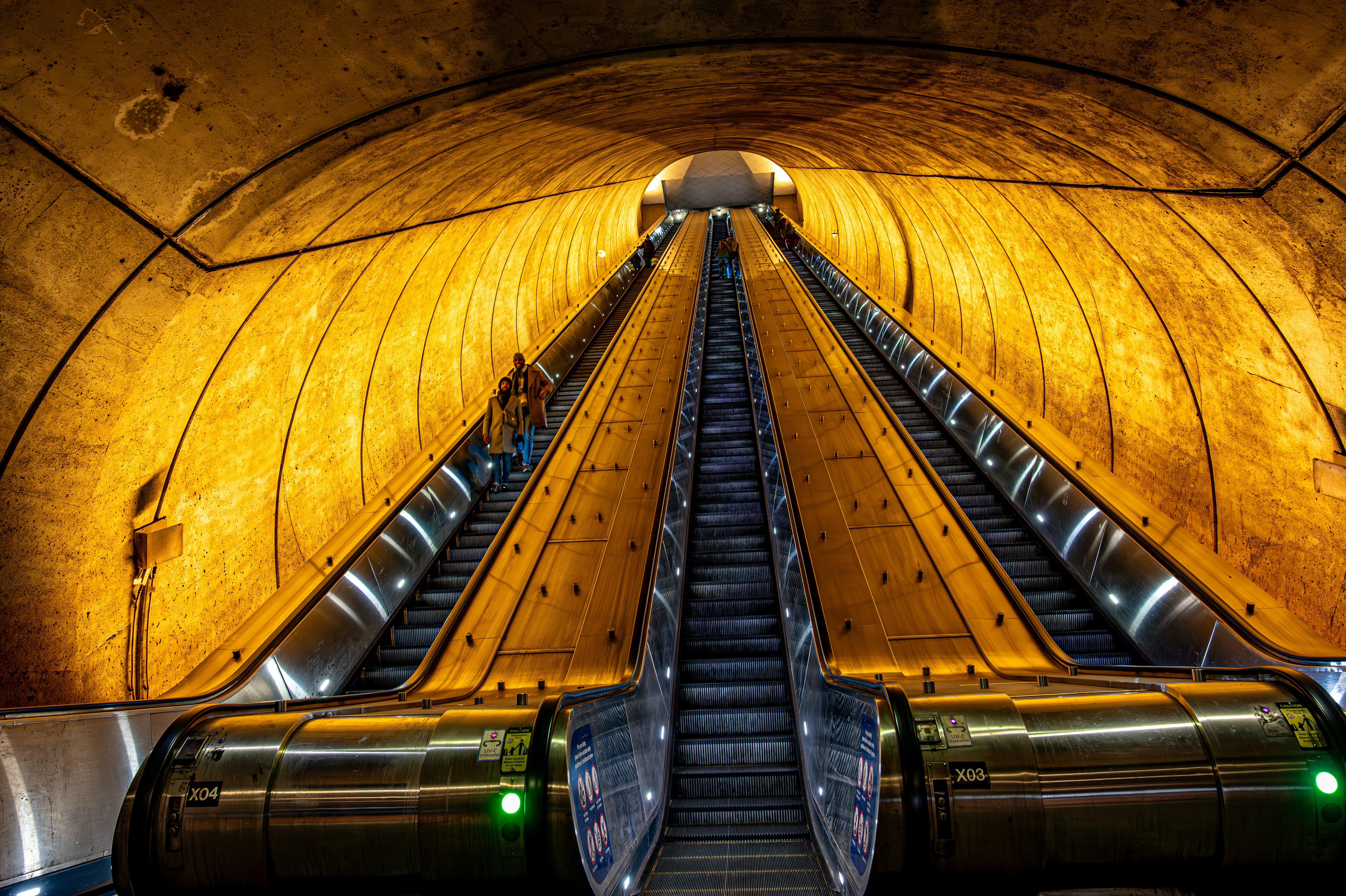 Two escalators ascend into a tunnel.