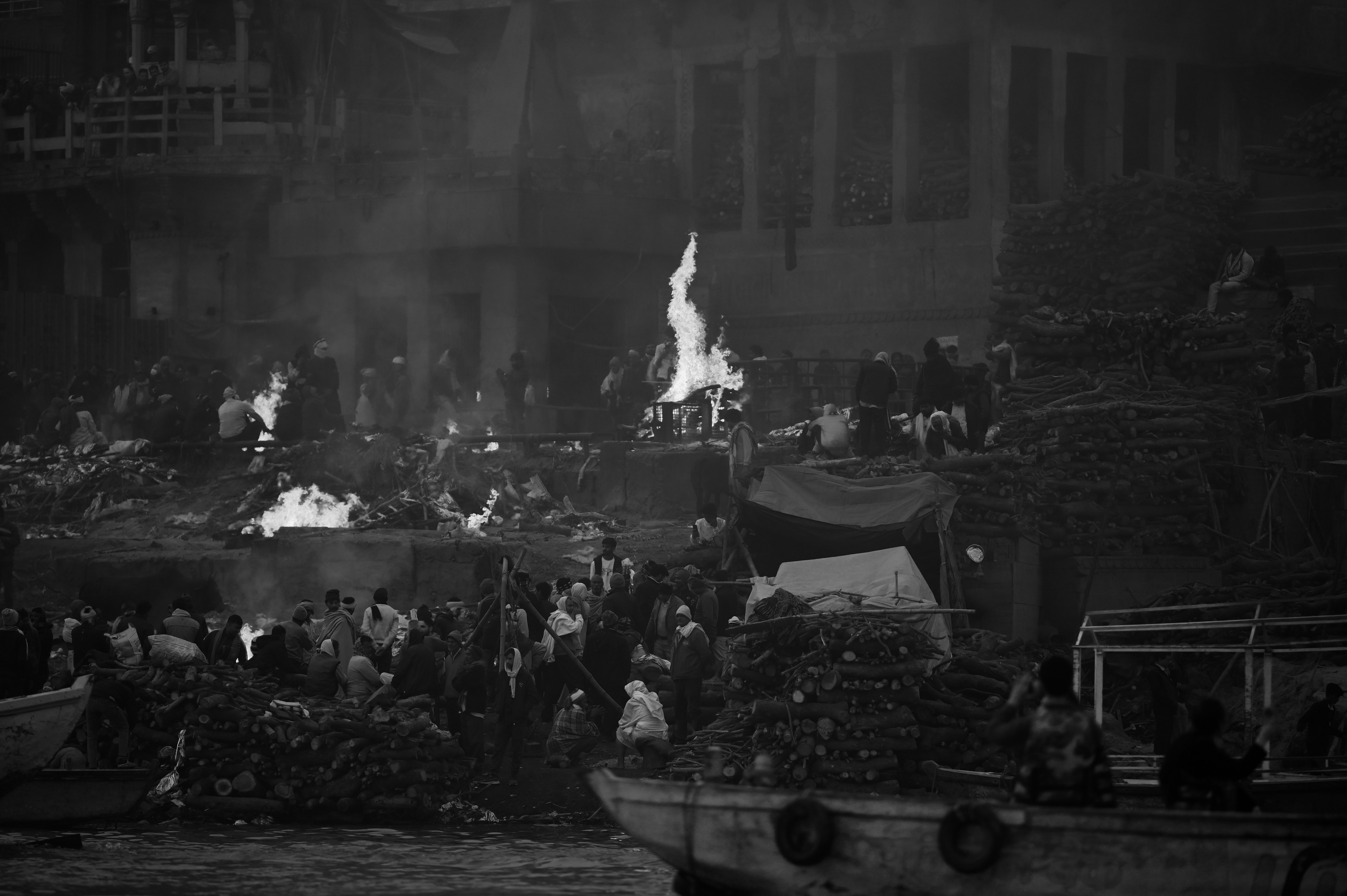 People gathered around fires on a riverbank