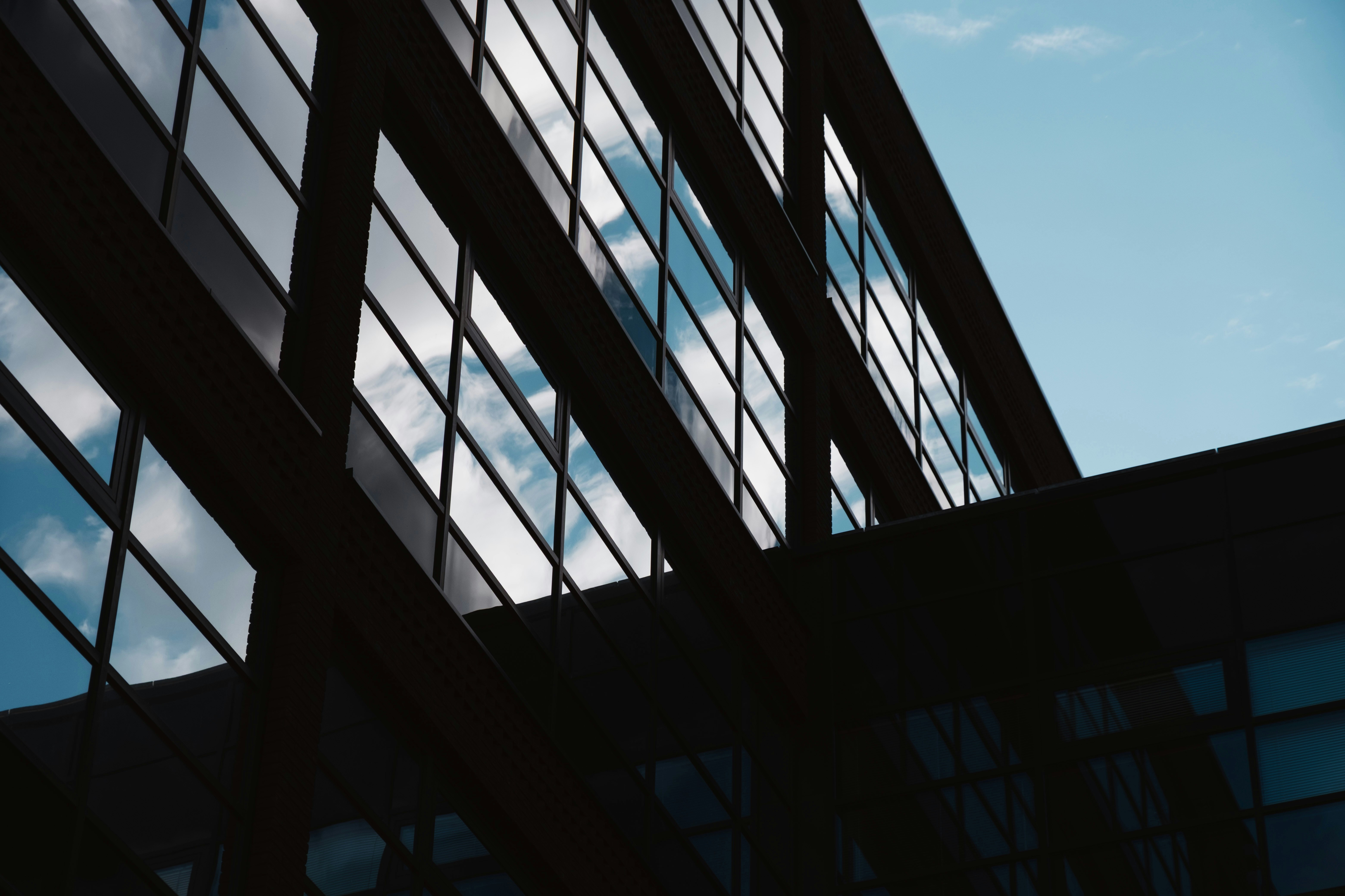 Modern building facade reflecting the sky and clouds