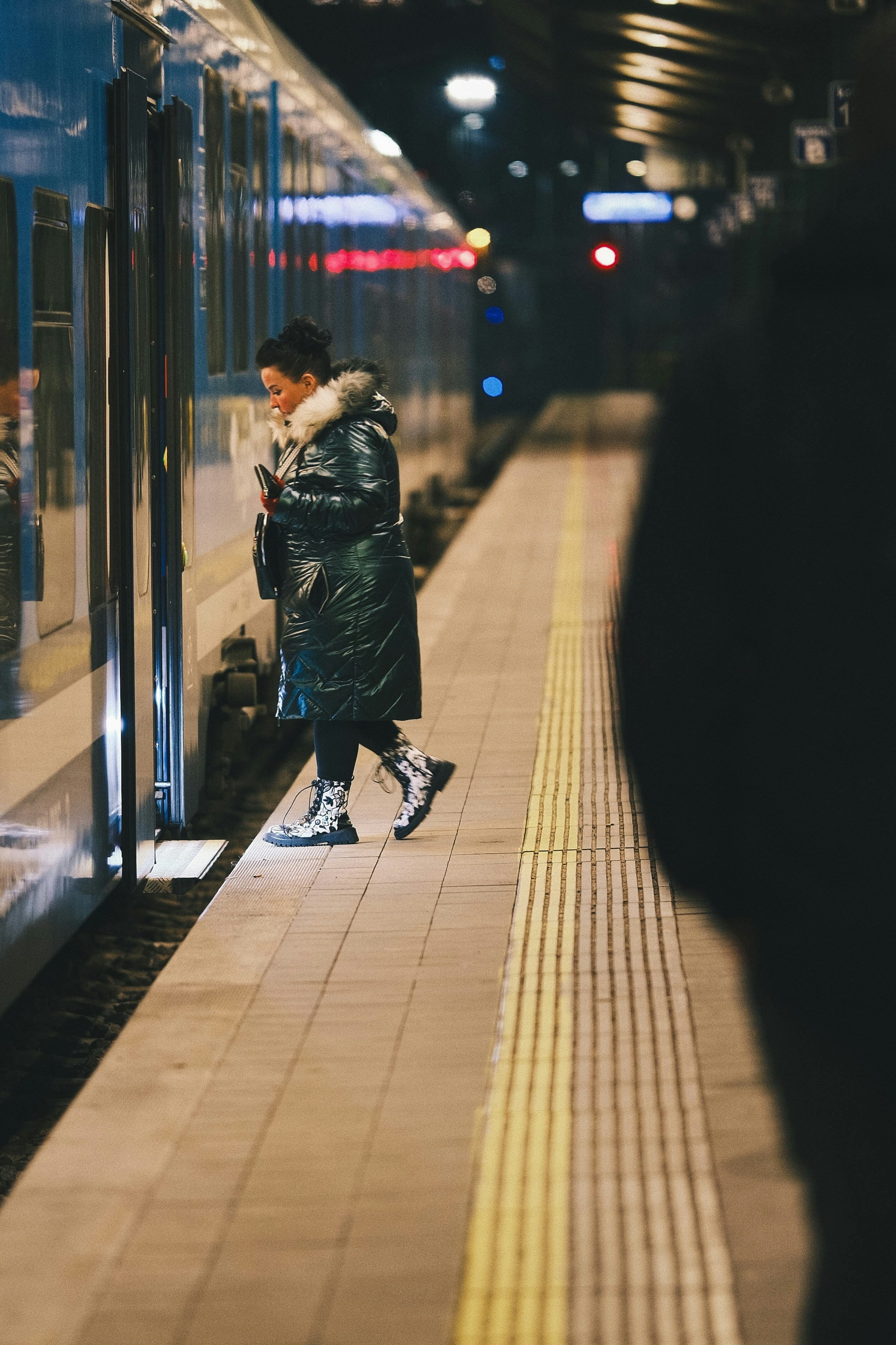 Woman boarding a train at night