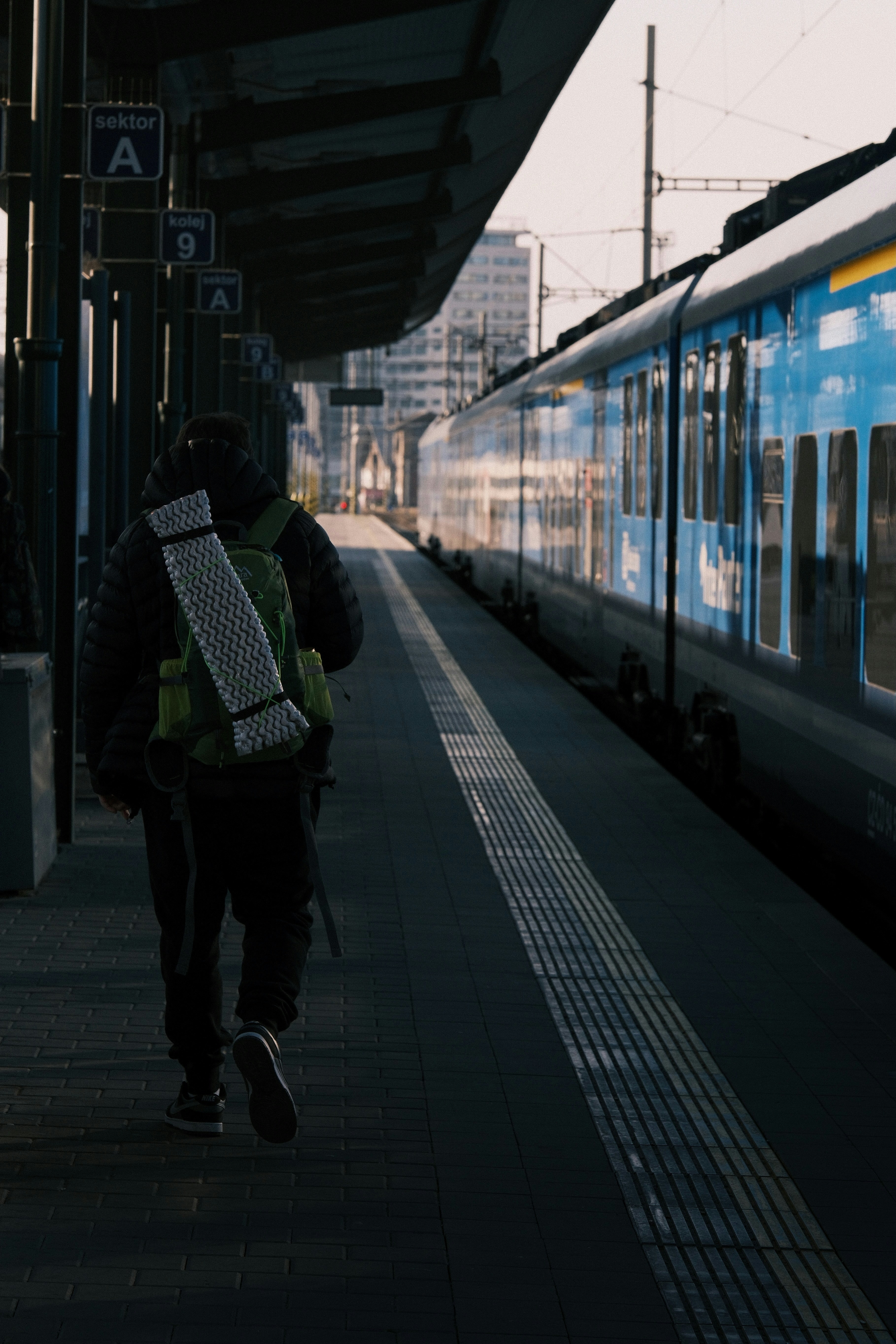 Person with backpack walking on train station platform