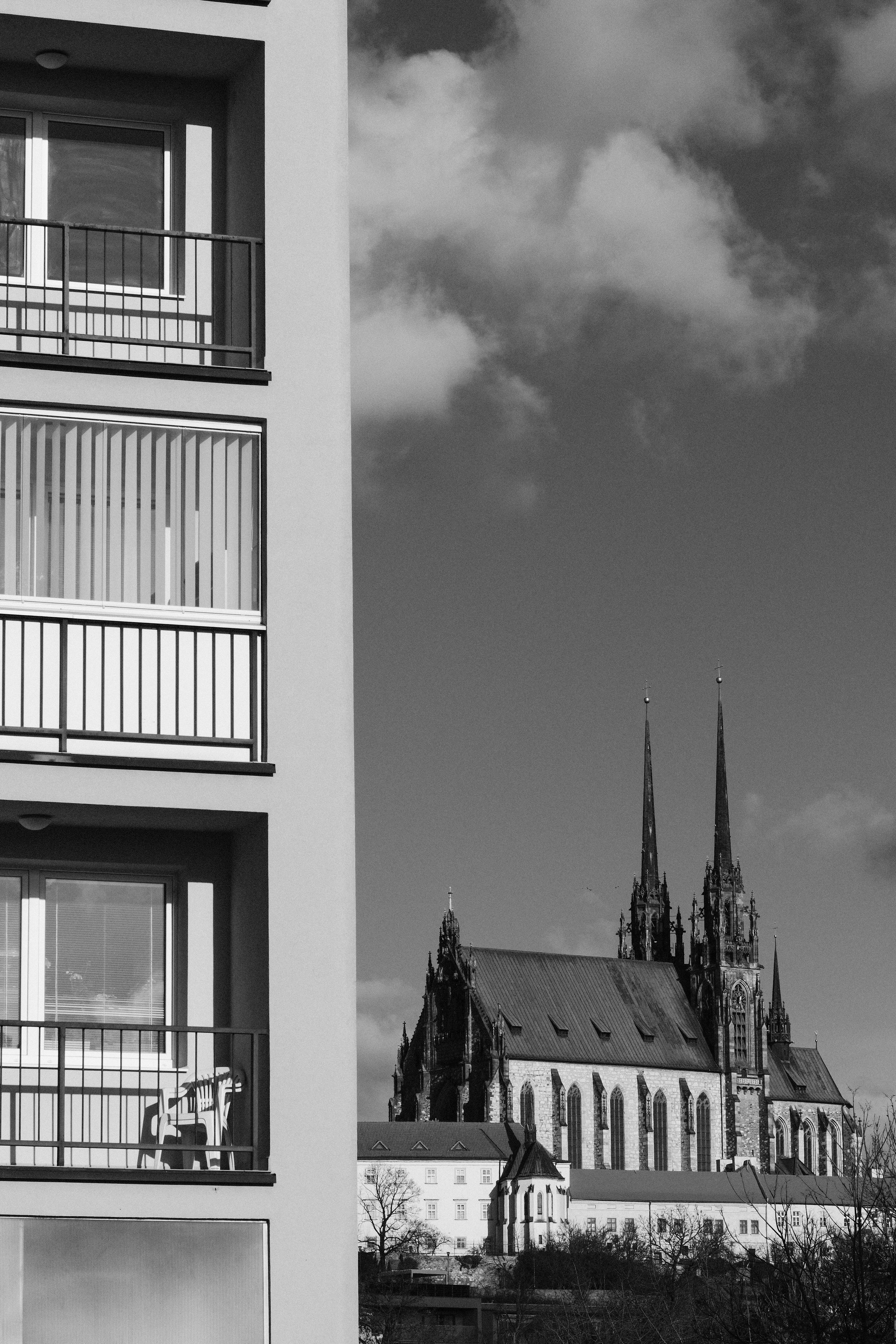 Modern building facade next to a gothic cathedral.