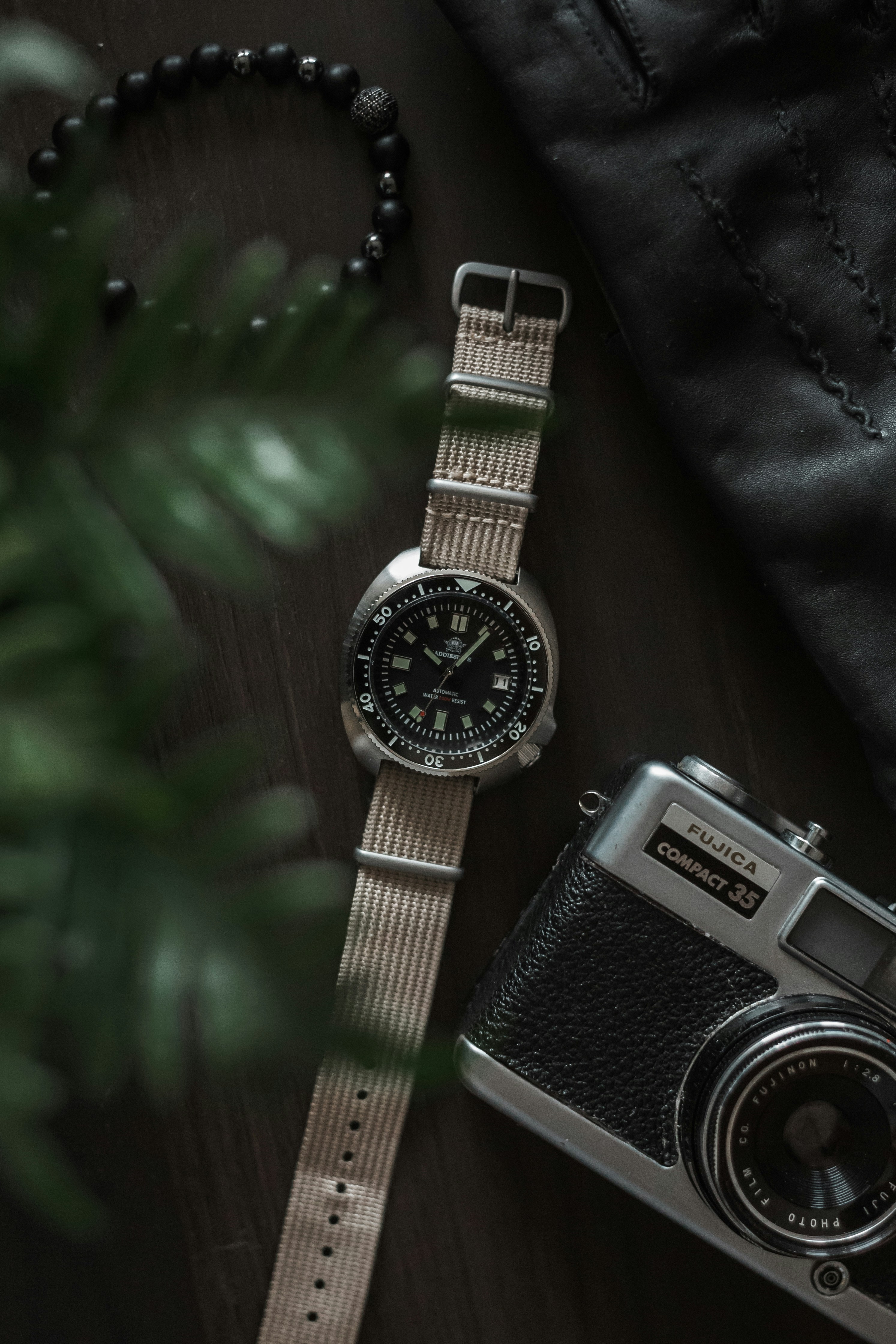 Watch and vintage camera on wooden surface