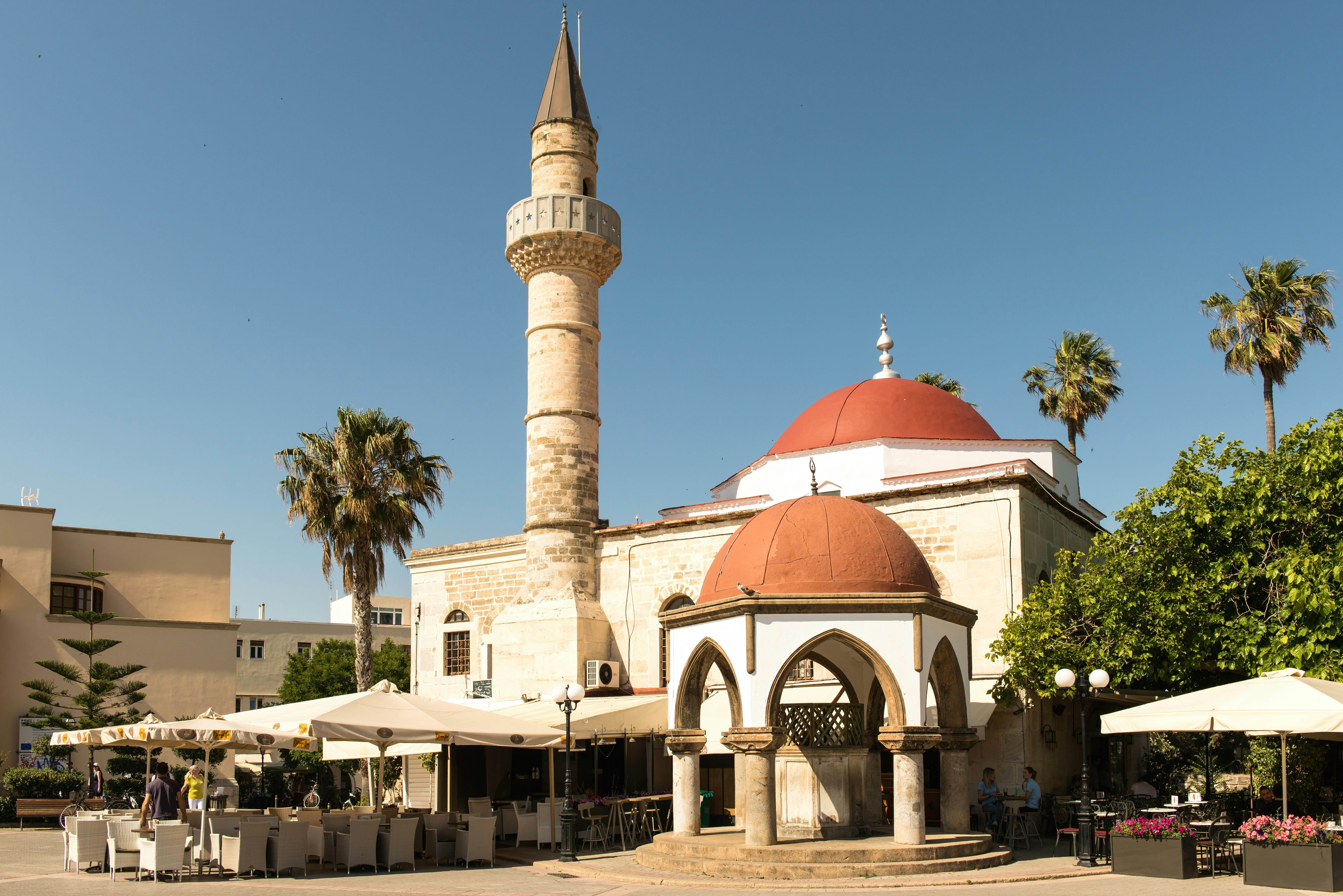 Mosque with red domes and minaret in sunny square