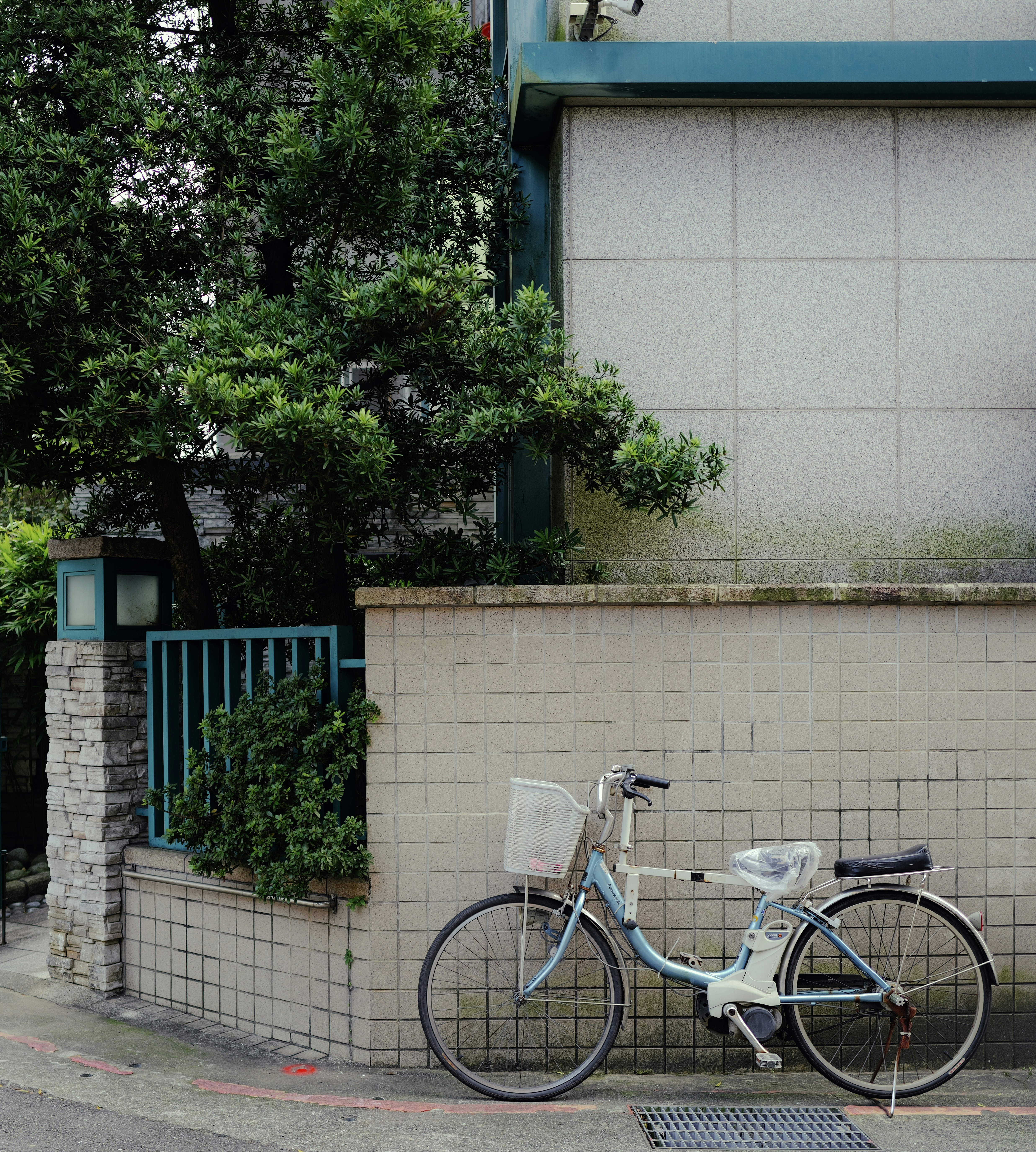 A light blue bicycle parked next to a wall.