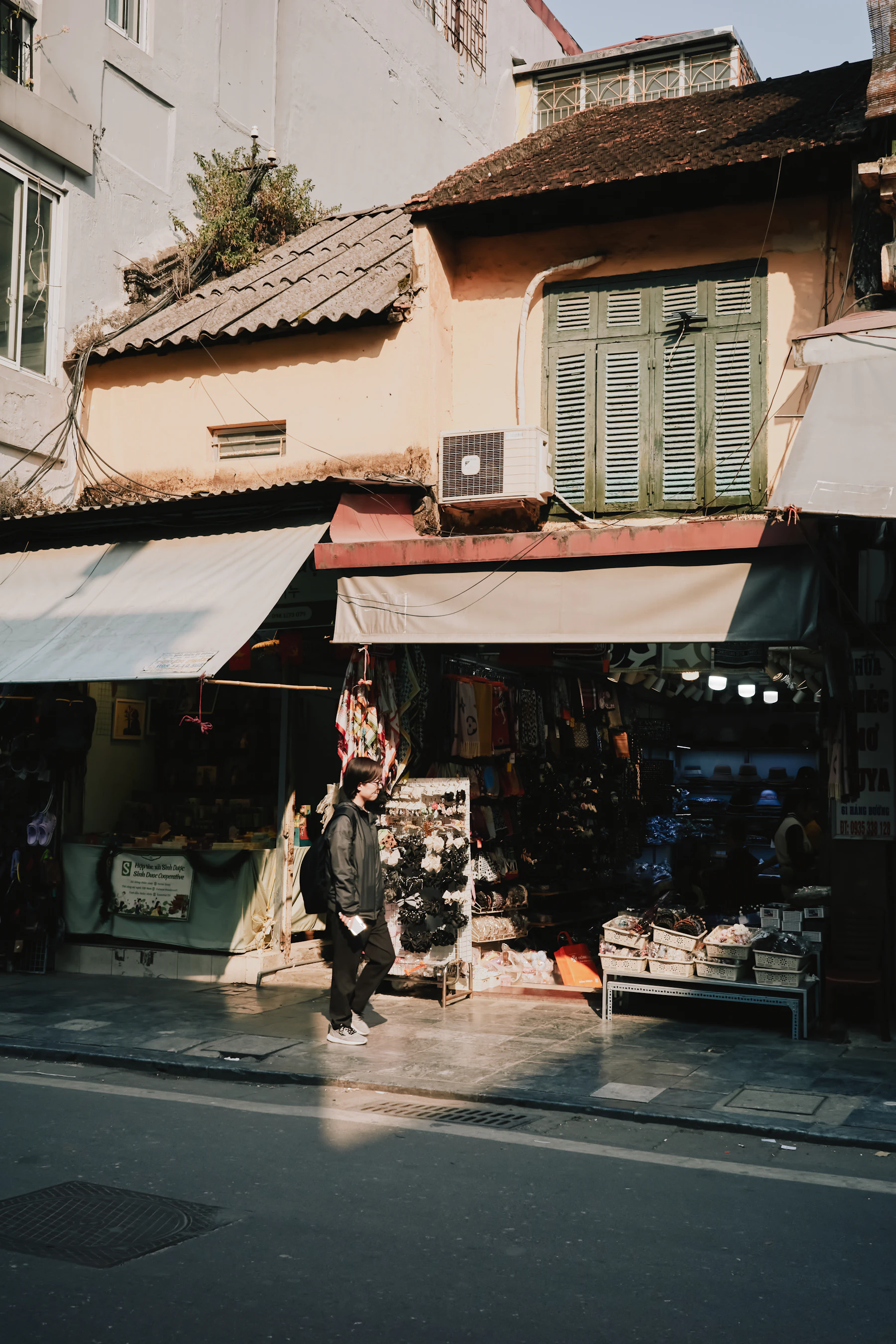 A person passing an everyday neighborhood storefront