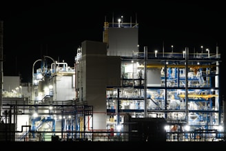 Industrial plant illuminated at night with complex machinery.