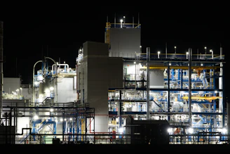 Industrial plant illuminated at night with complex machinery.