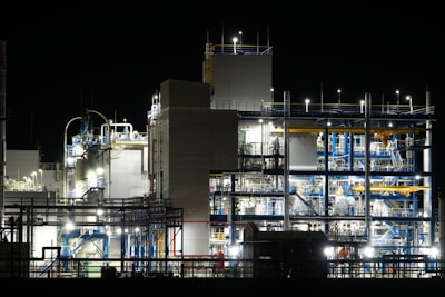 Industrial plant illuminated at night with complex machinery.