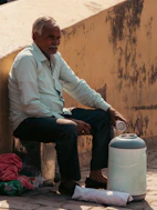 Elderly man sitting next to a water cooler