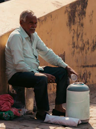 Elderly man sitting next to a water cooler