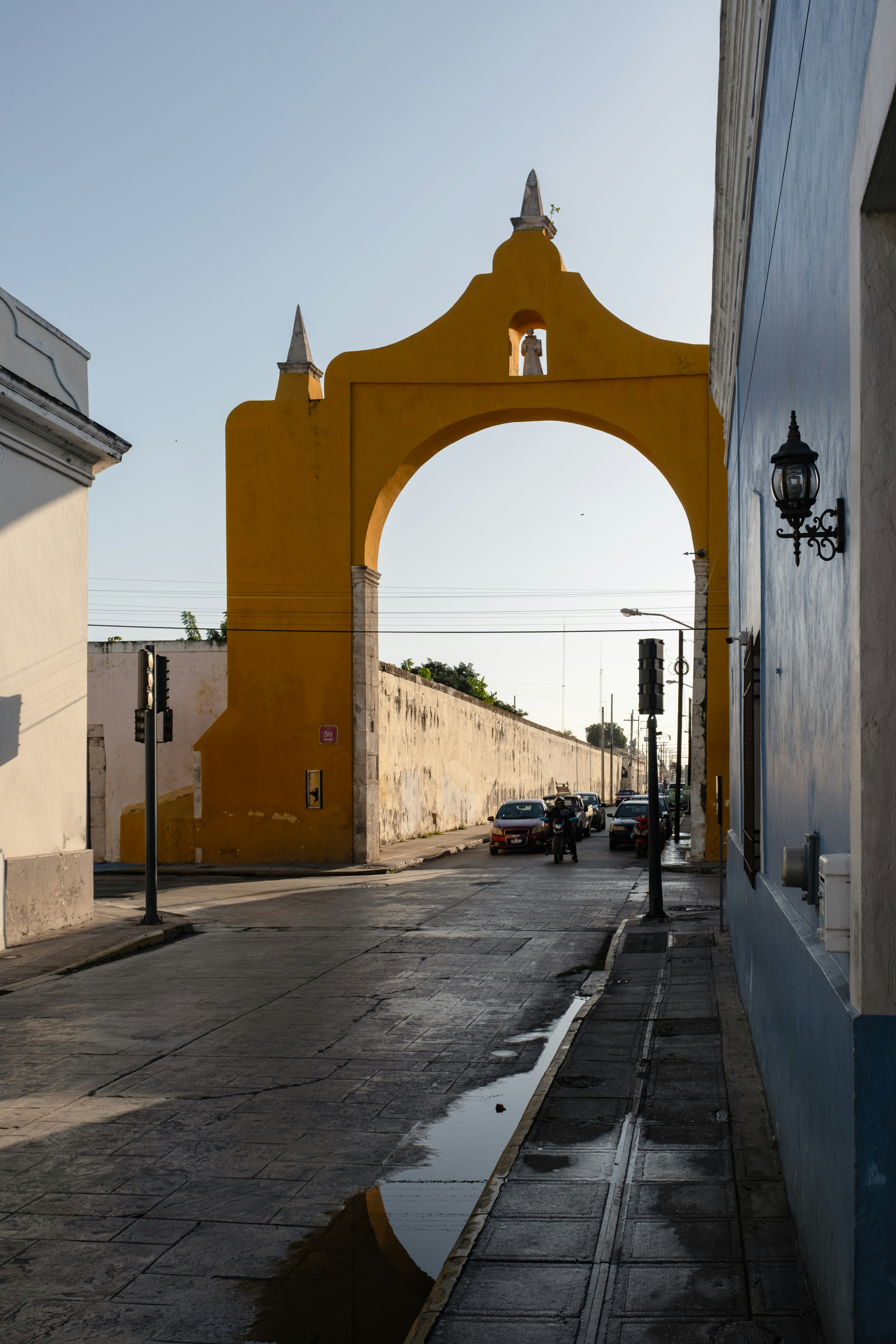Yellow archway over a street with cars