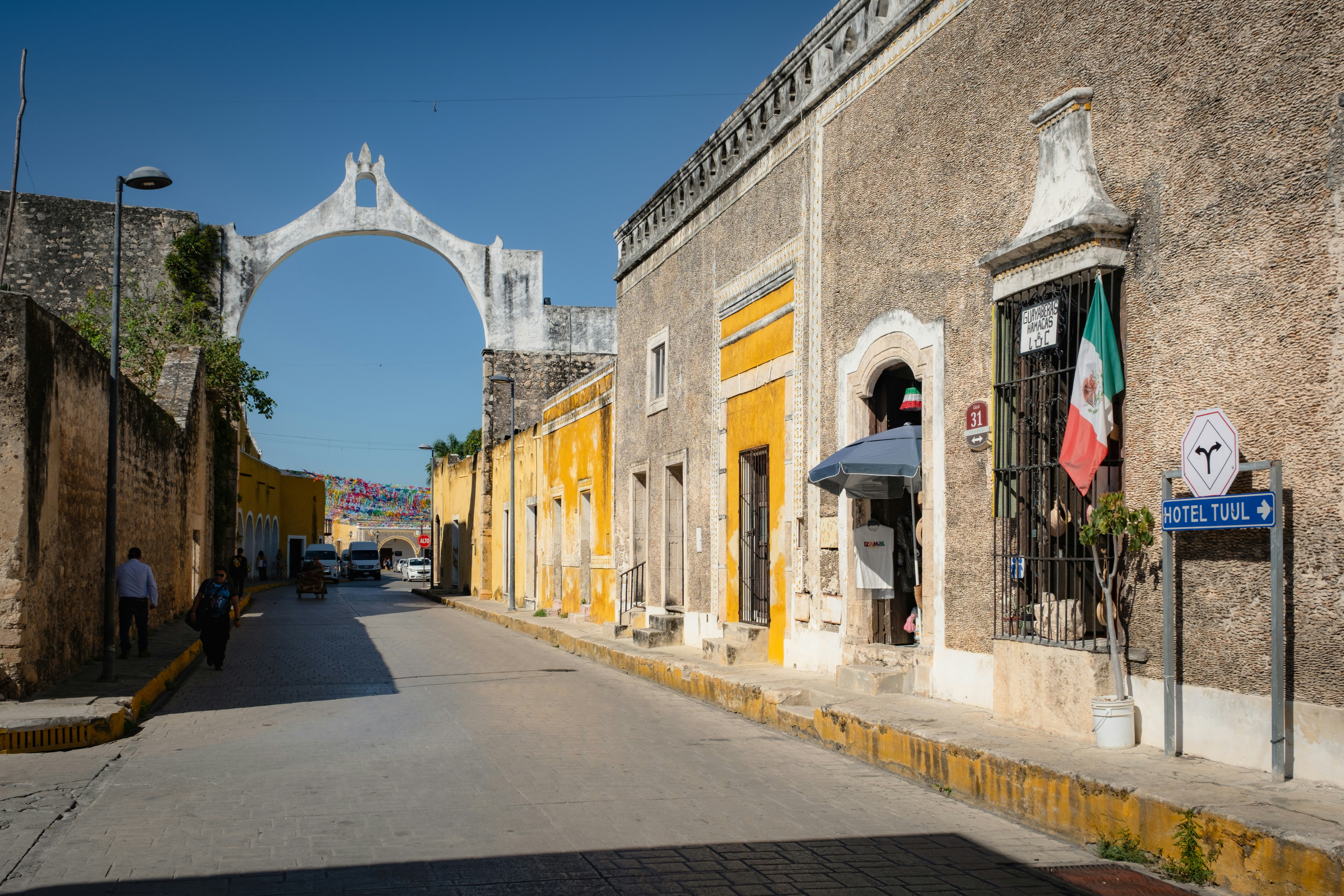 Colonial street with arch and mexican flag