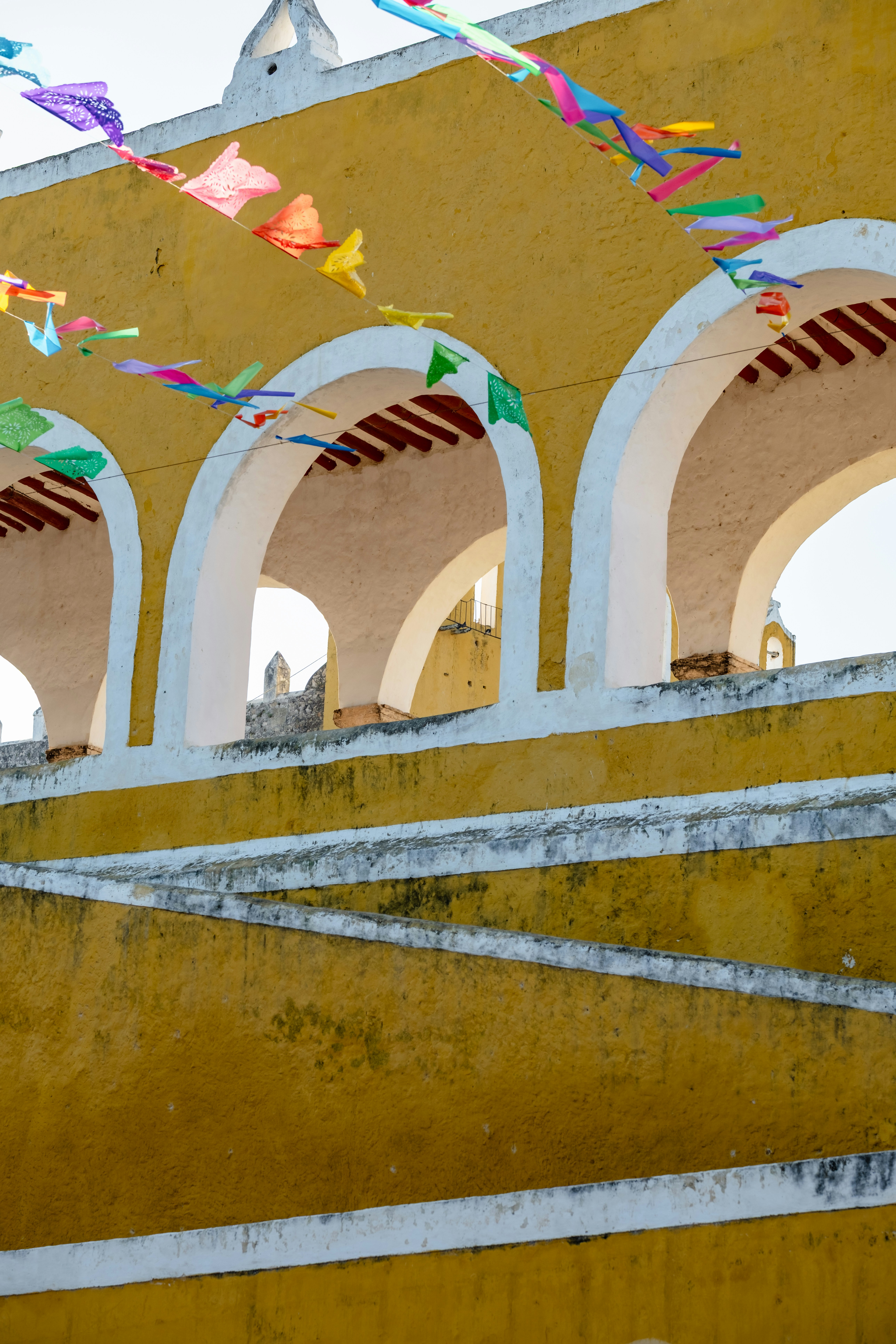 Yellow arched building with colorful festive banners