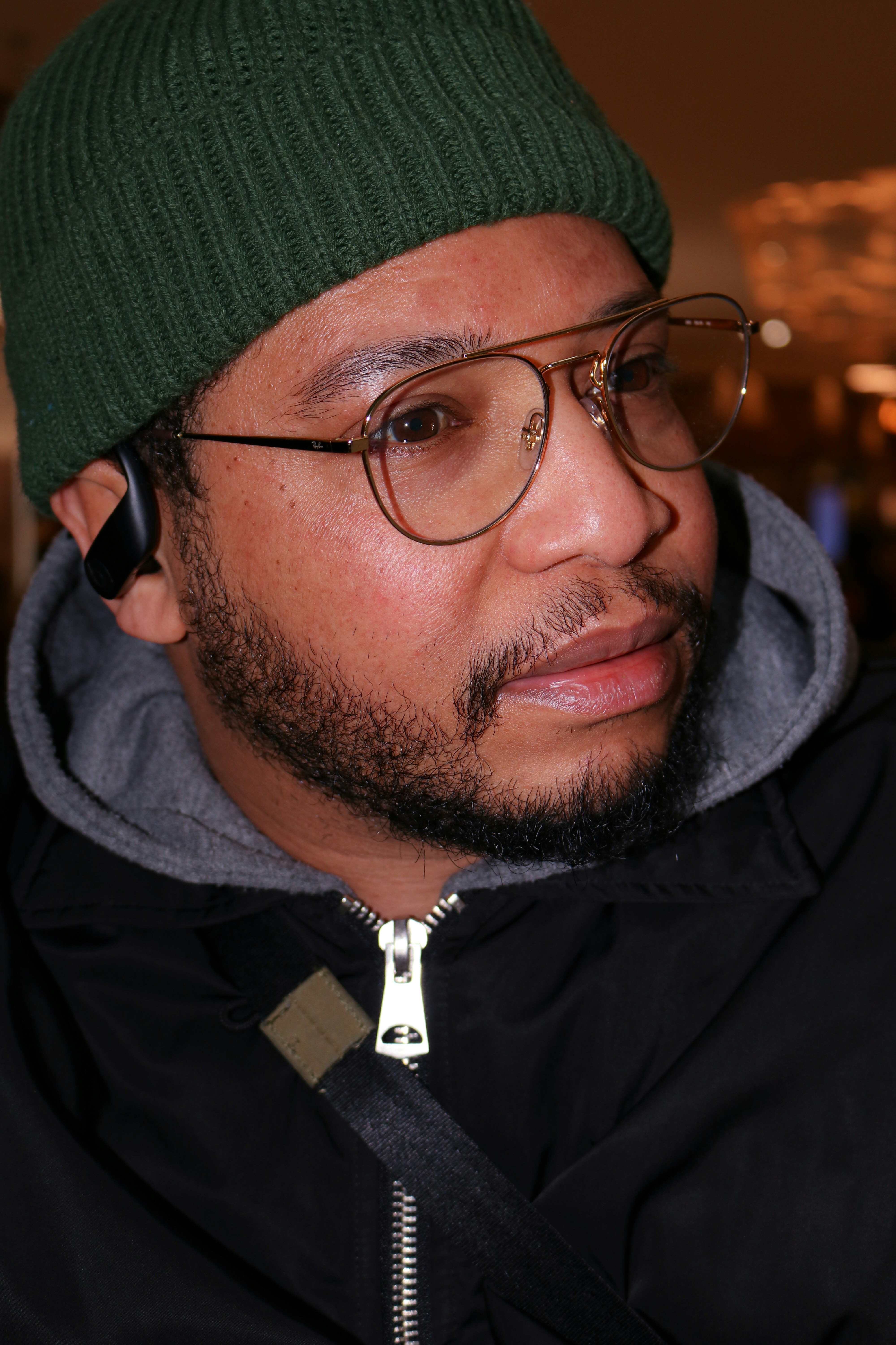 Marcus Hill, barber, in a green beanie and glasses