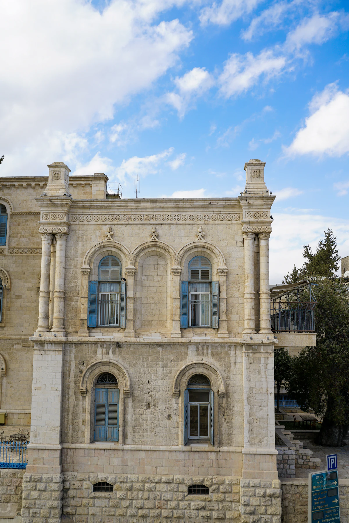 An older Jerusalem stone building with blue shutters