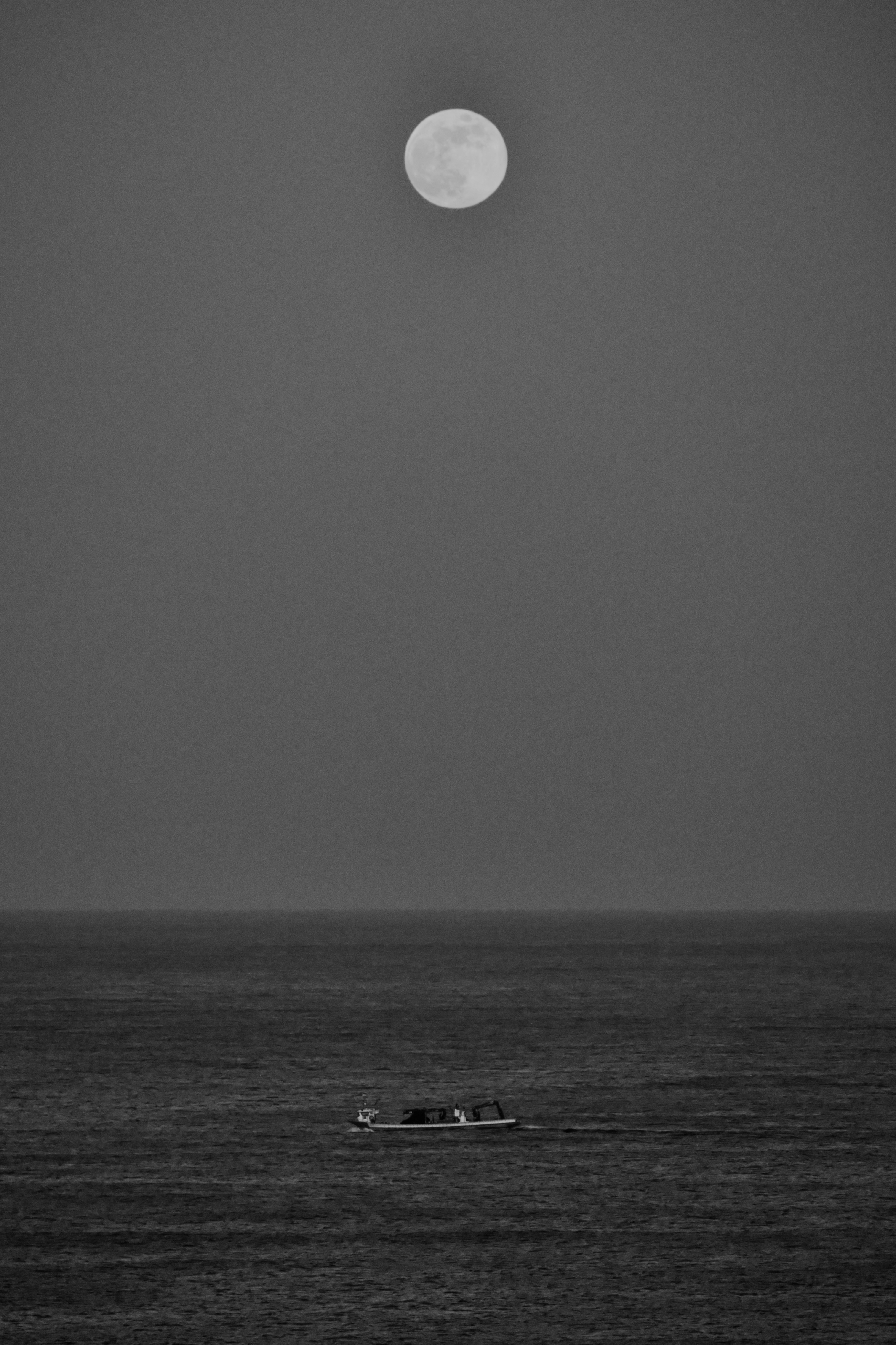 Full moon over a boat on the ocean