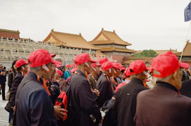 Group of people wearing red hats at forbidden city.