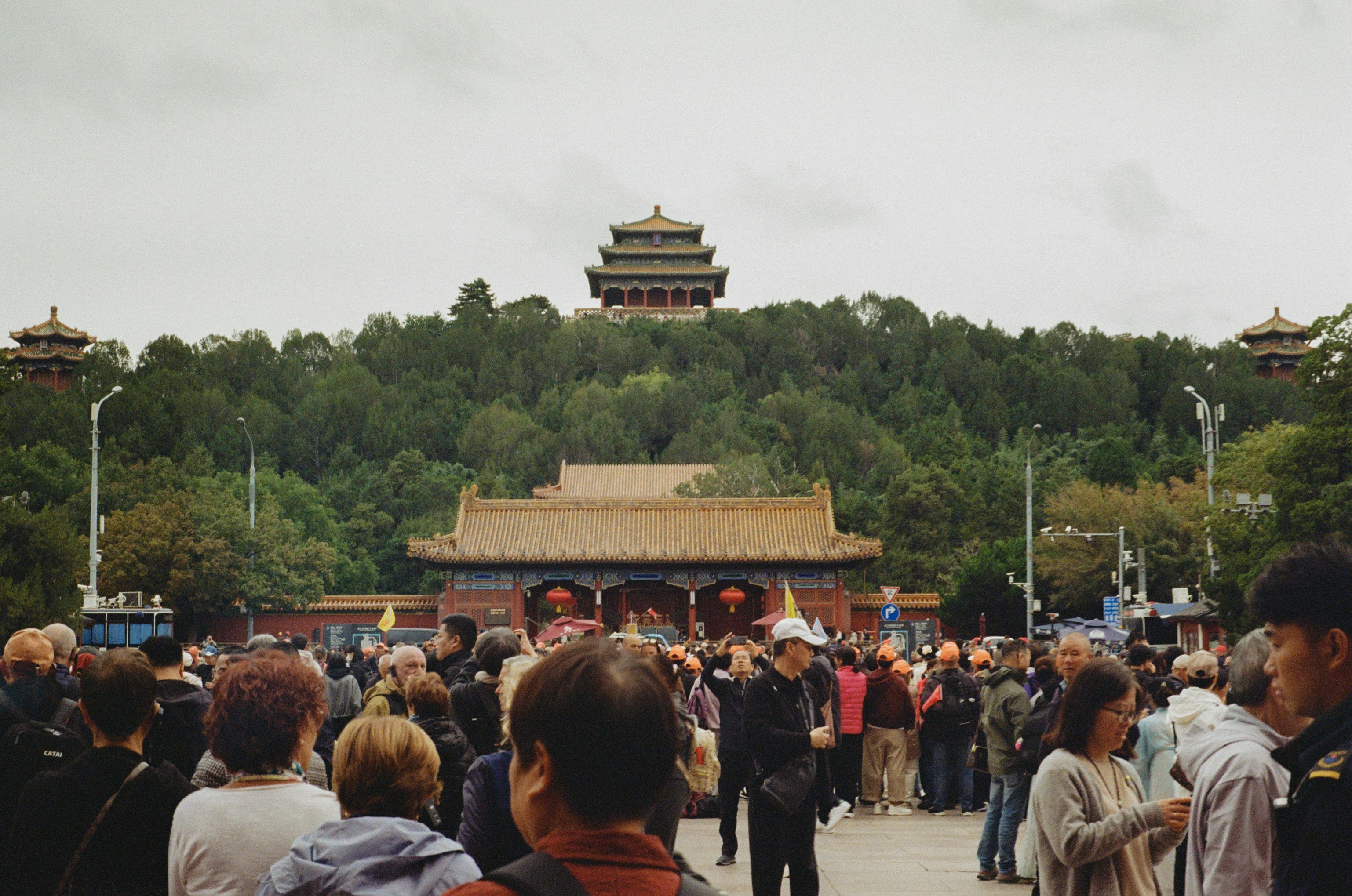 Menschenmenge versammelt sich an einem historischen Gebäude auf einem Hügel