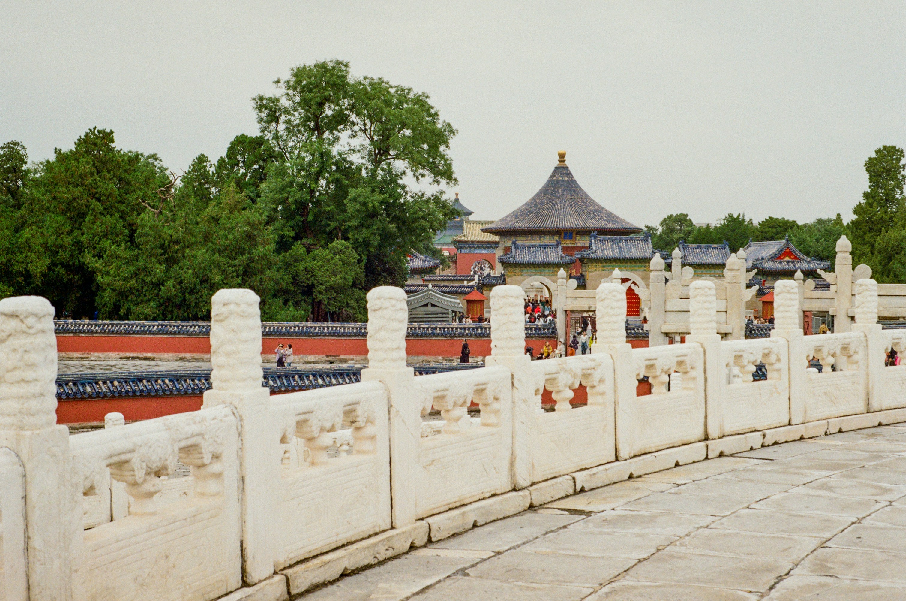 Verzierte weiße Steinbalustrade mit antiker chinesischer Tempelarchitektur.