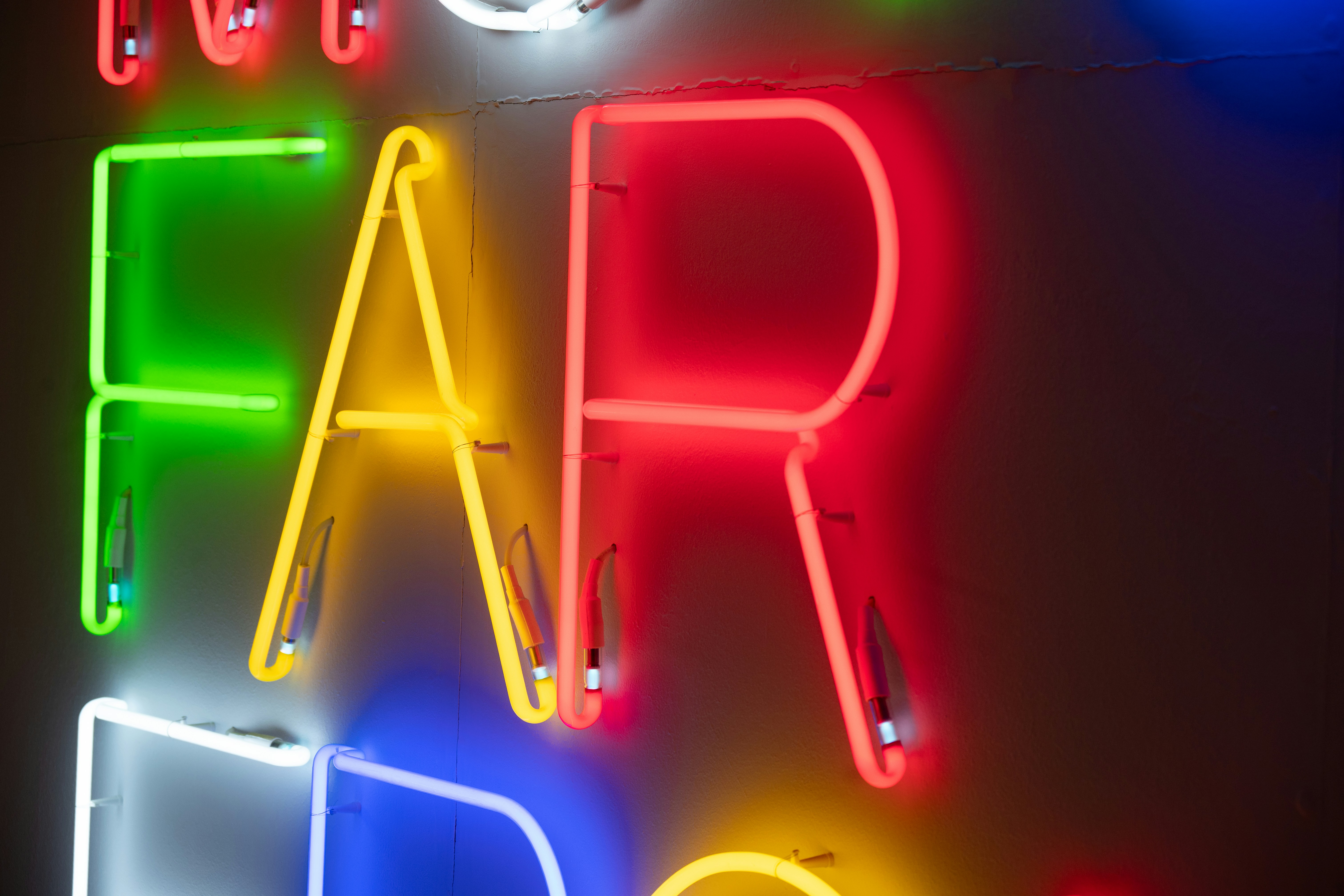 Letras neon coloridas soletrando palavras na parede