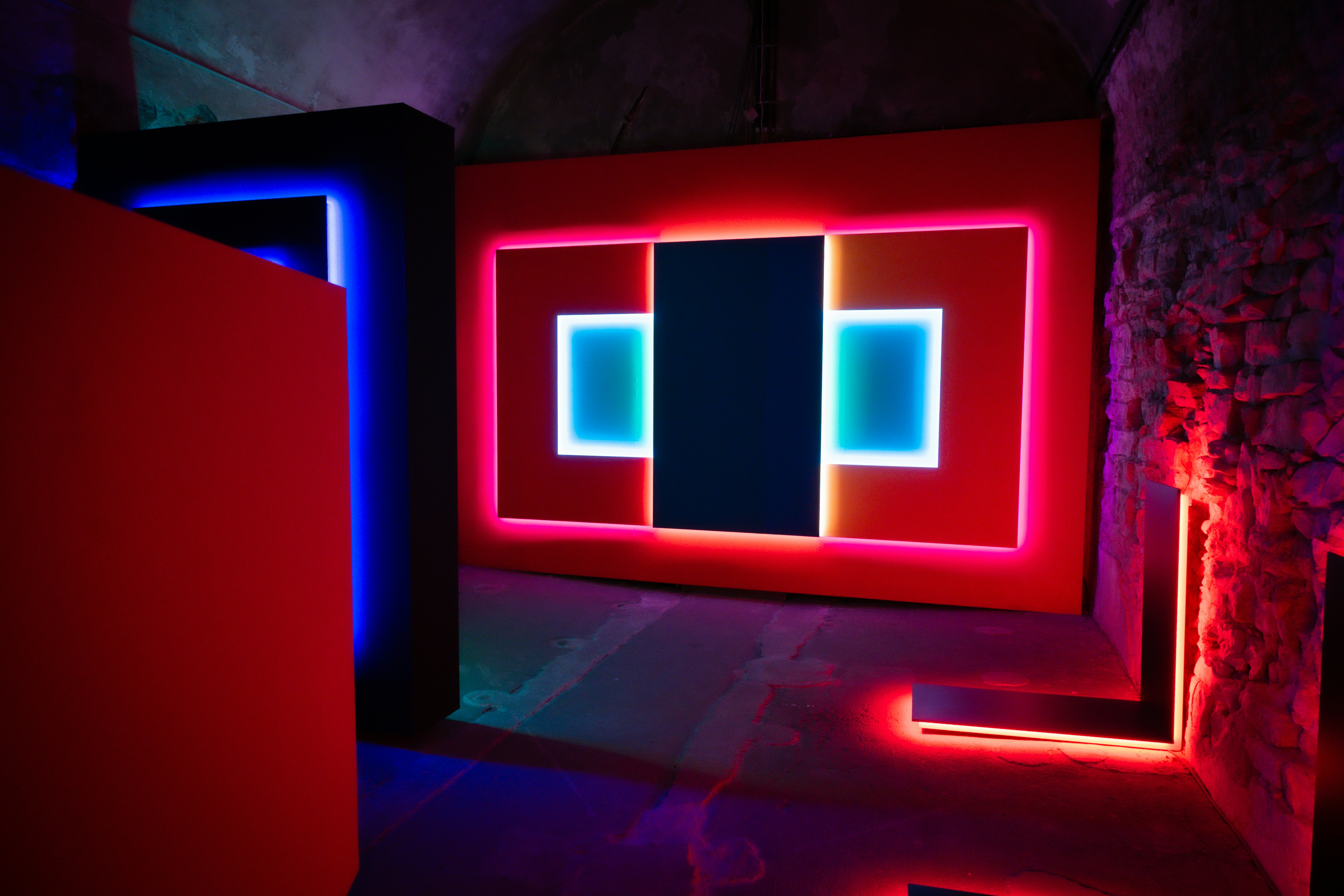 Modern room with colorful neon lights and geometric shapes.