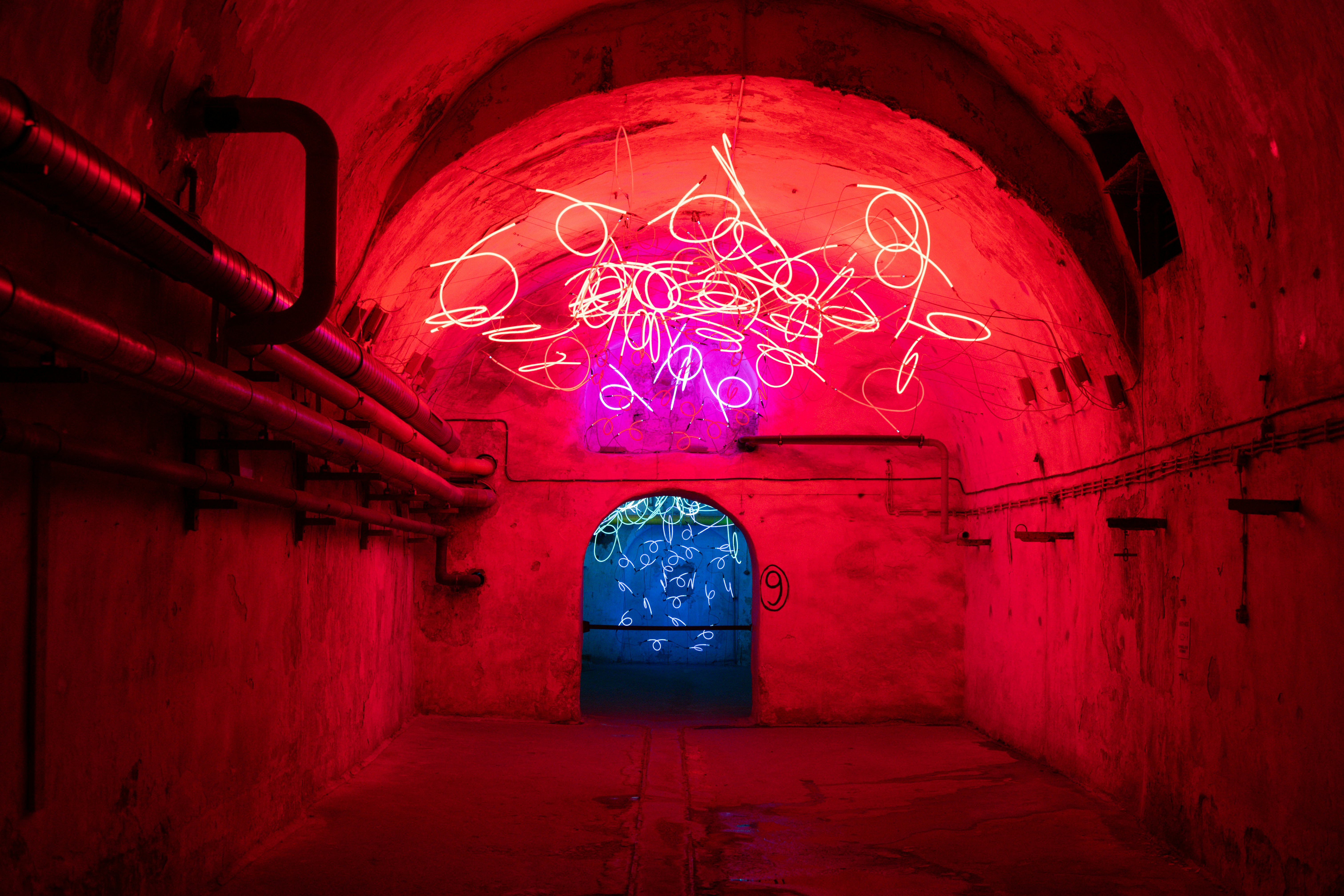 Neon art installation in a red illuminated tunnel