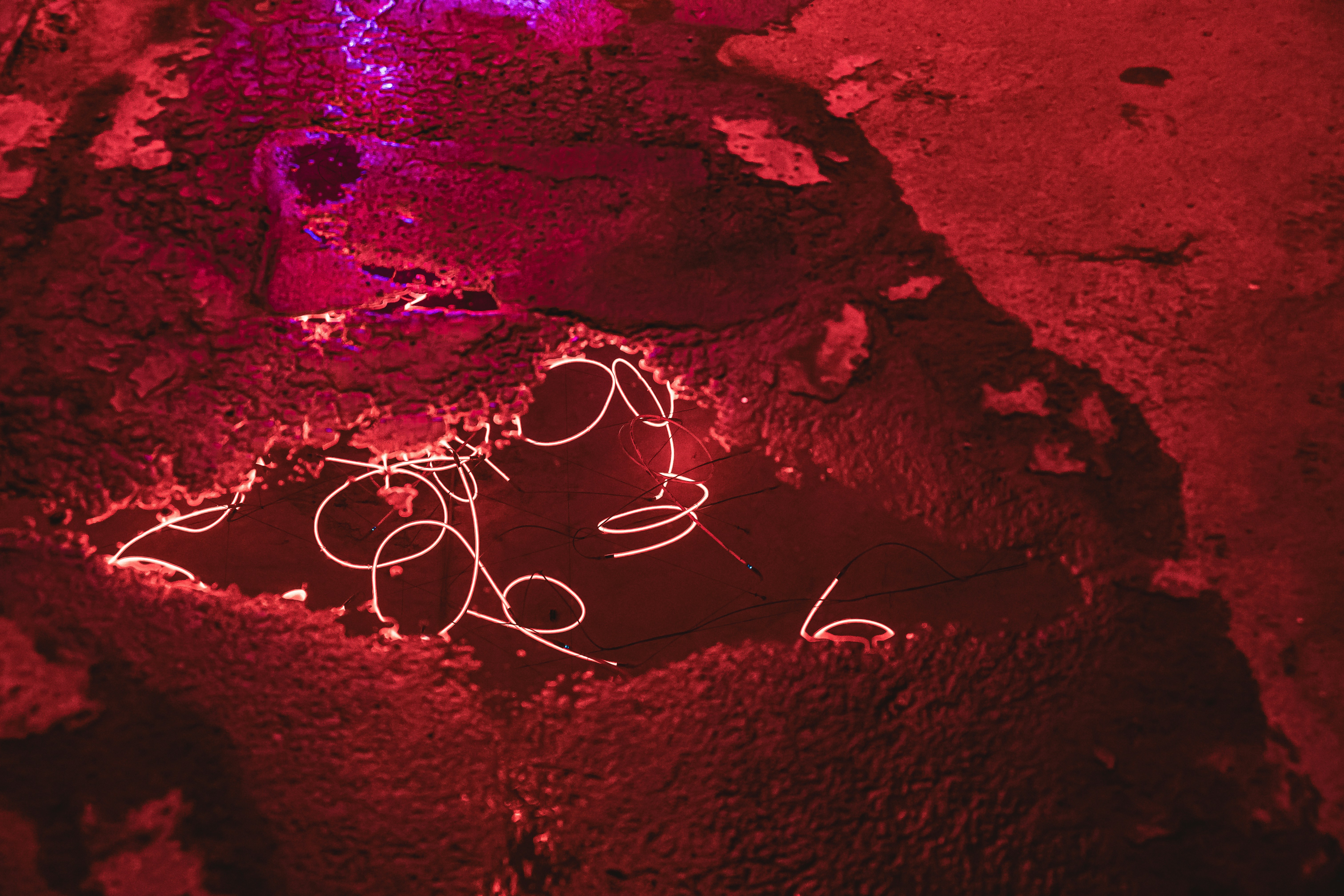 Abstract red textured surface with white swirling lines.