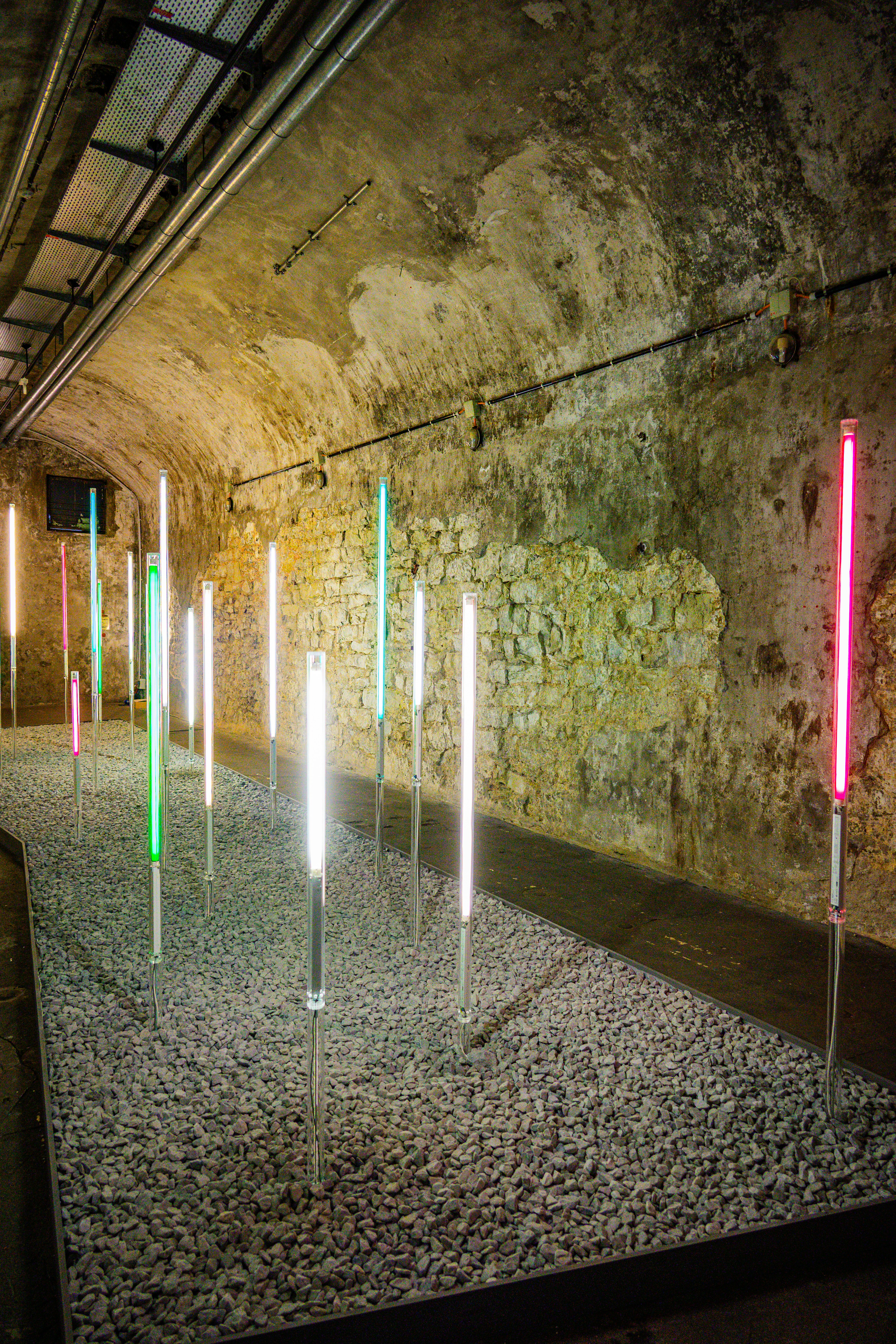 Colored lights illuminate a stone tunnel exhibition
