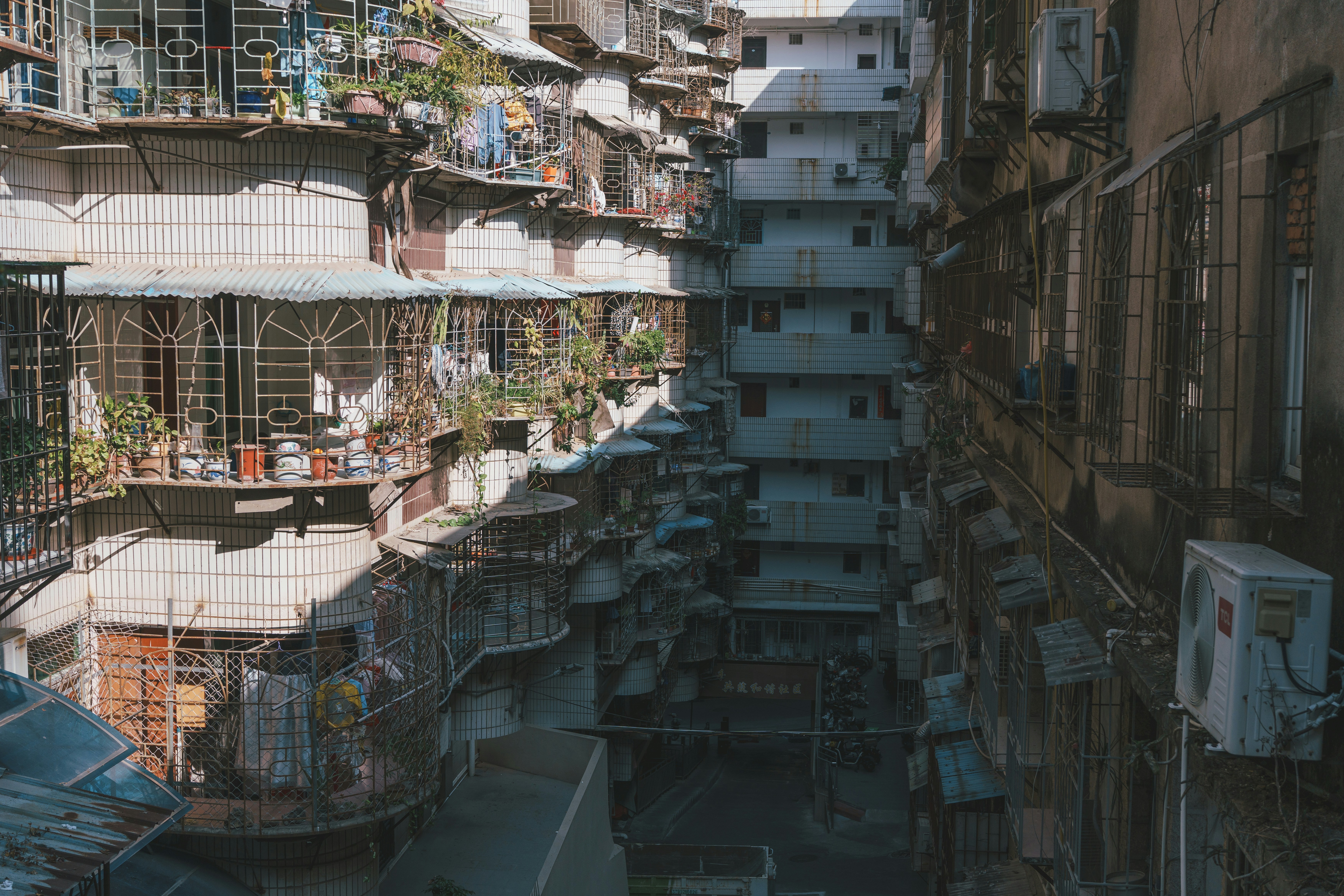 Tall apartment buildings with many balconies and air conditioners.