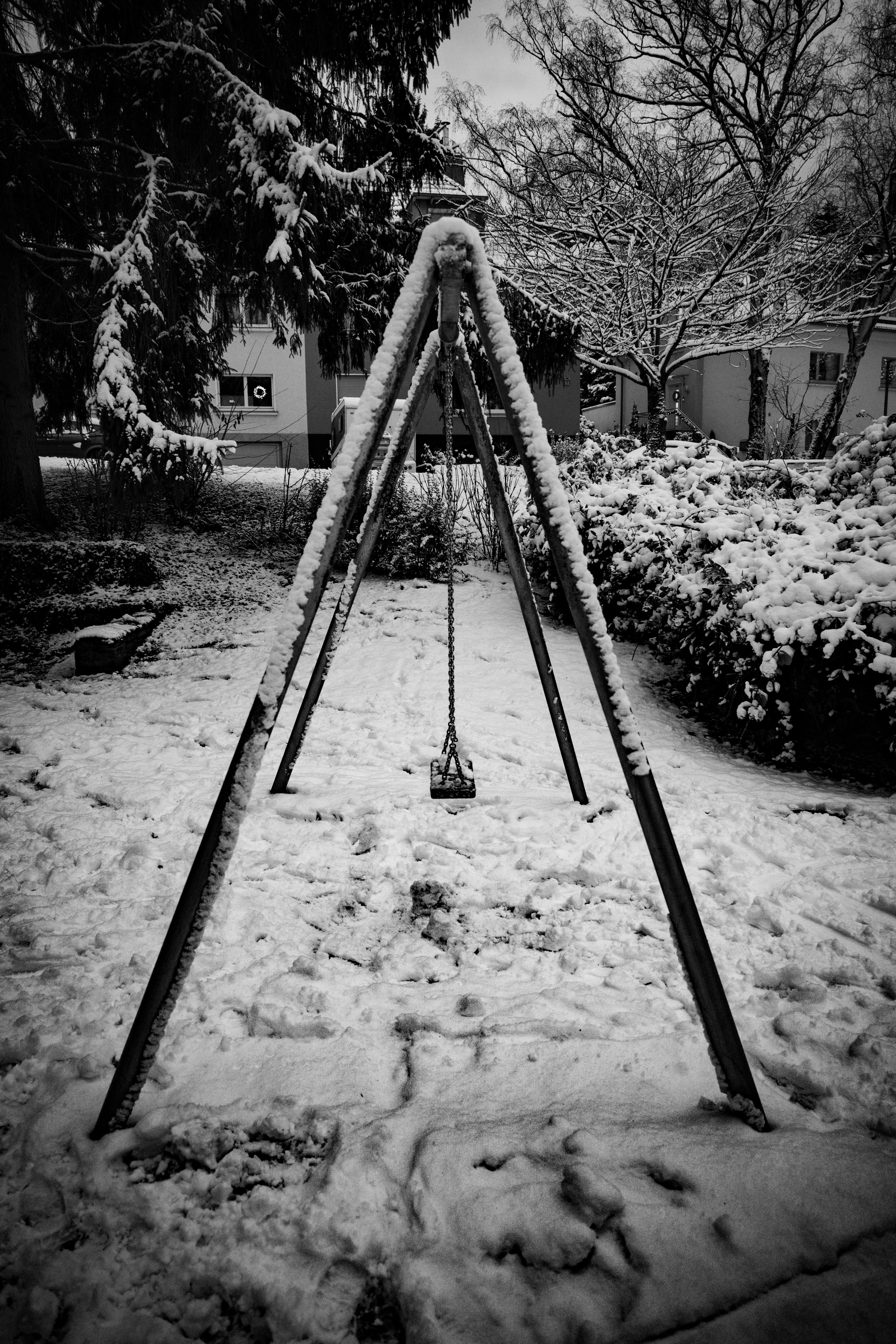 A snow-covered swing set in a park.