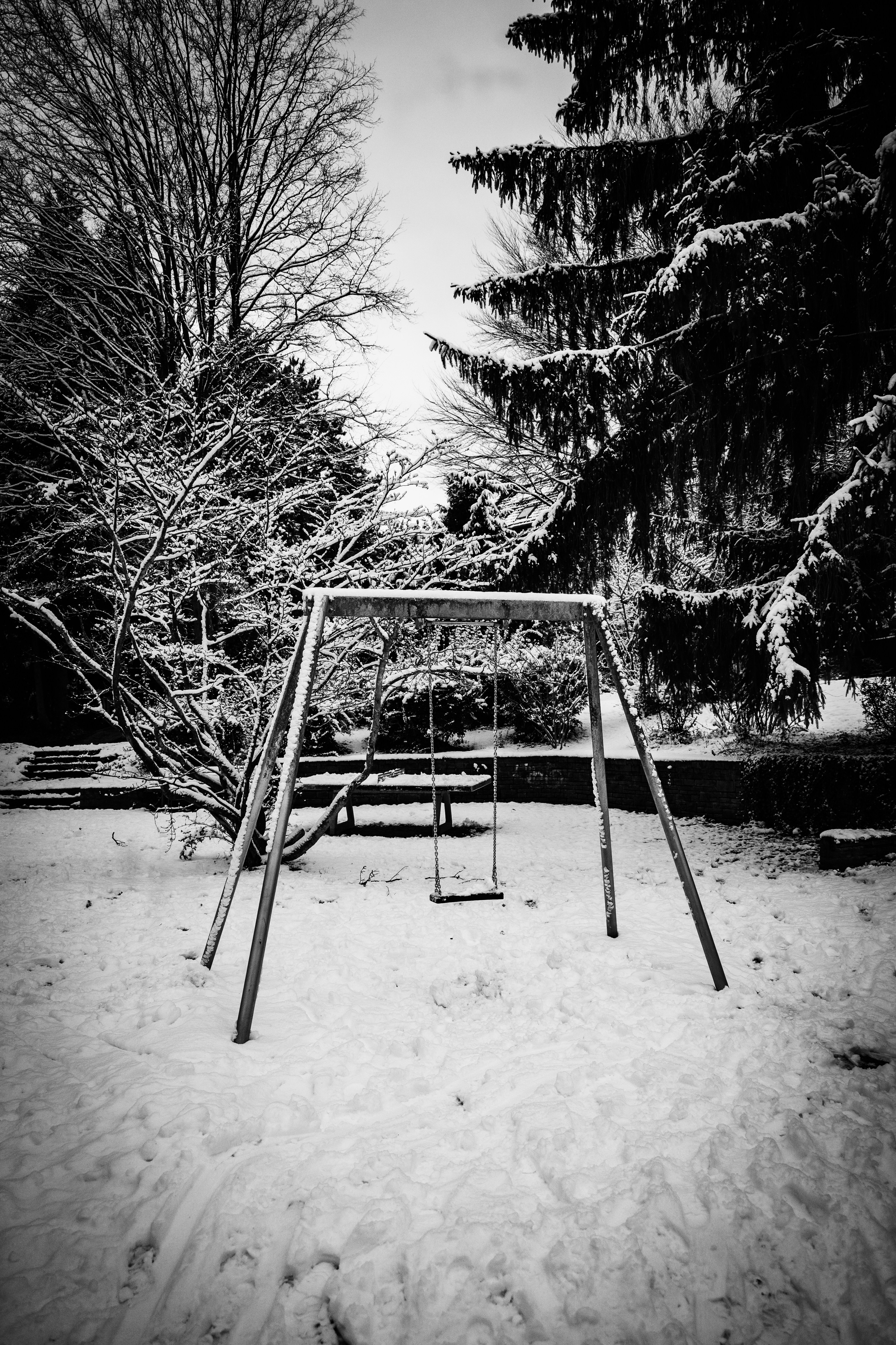A swing set stands in a snowy park.