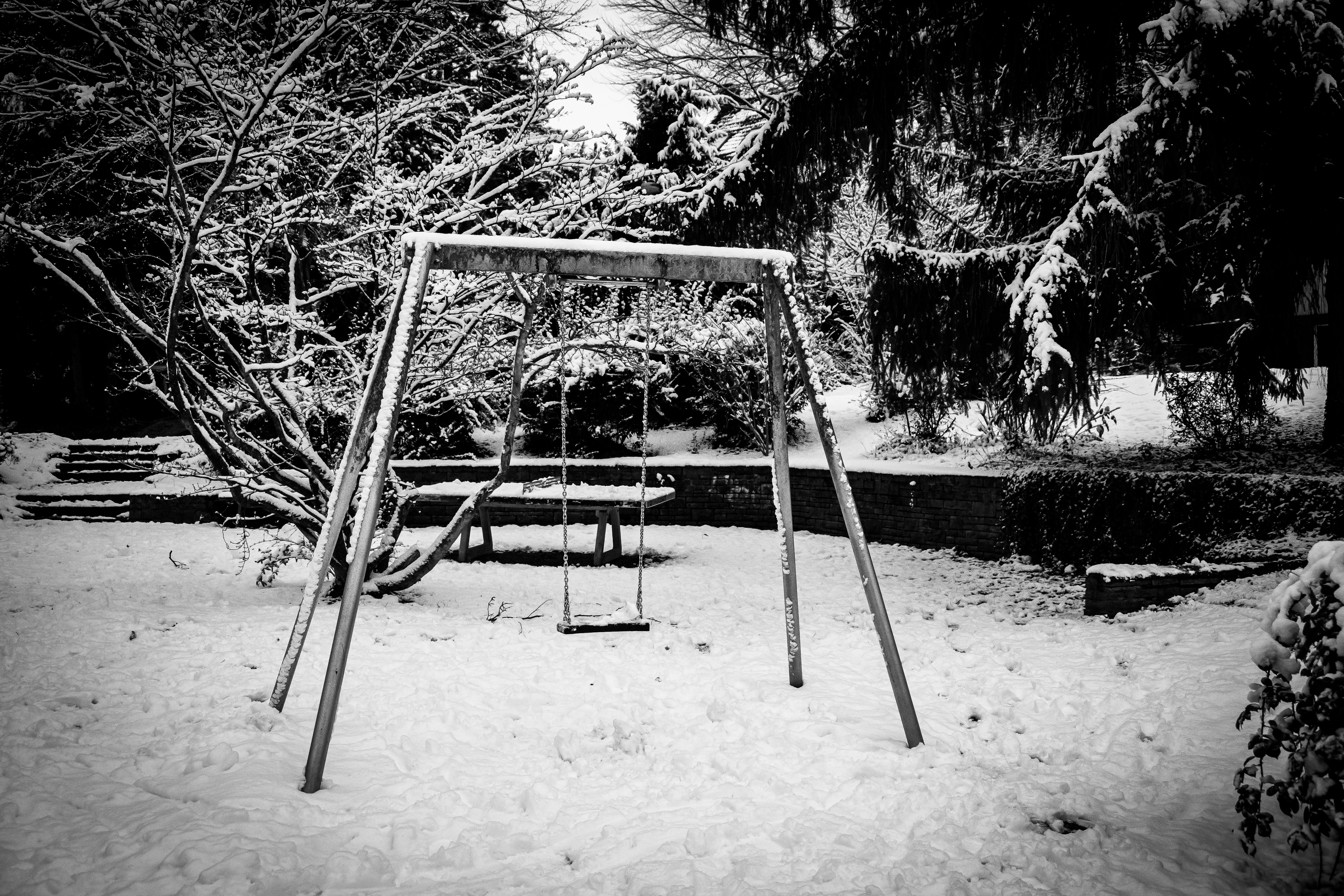 A metal swing set covered in snow.
