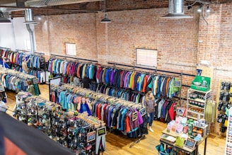 Retail store interior with racks of colorful clothing.
