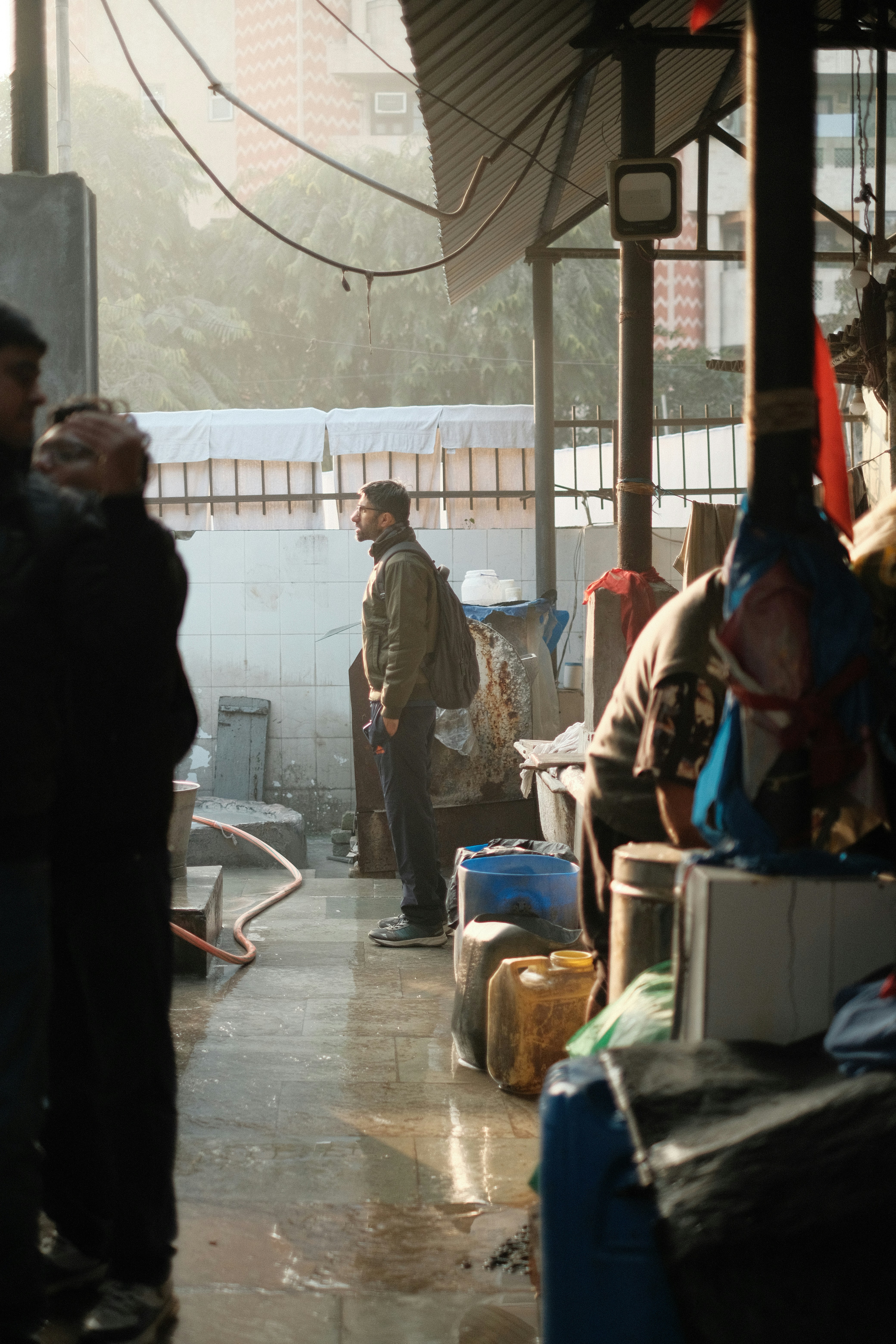 Man standing in a wet market with goods.