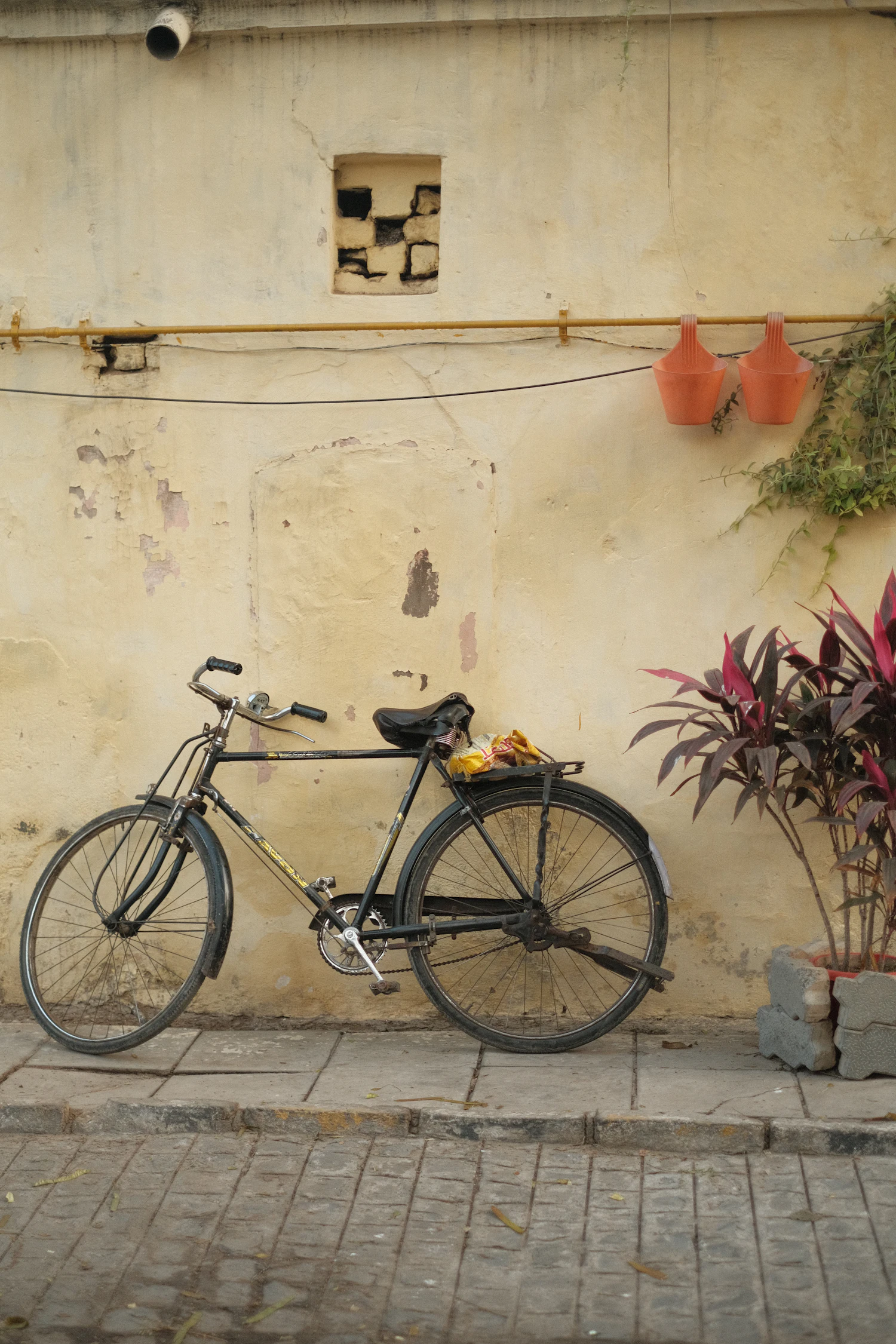An old bicycle leaning against a textured wall